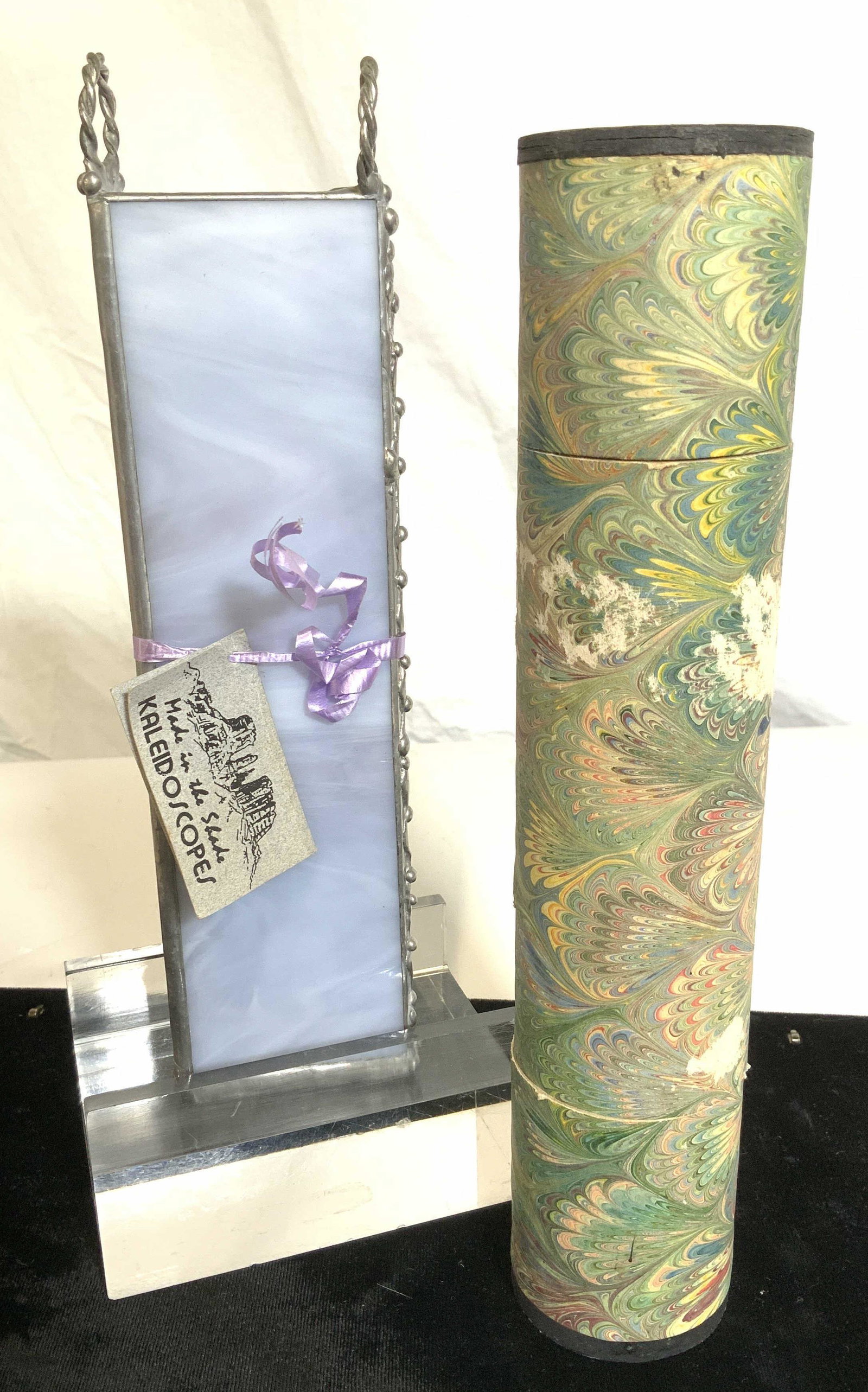 Lot 2 Vintage & Modern Handcrafted Kaleidoscopes: Vintage tubular kaleidoscope wrapped in paper, center twists, appears in working. Modern kaleidoscope is hand crafted of stained glass, triangular shape with original info card. Can be hung. 9 in. Pro