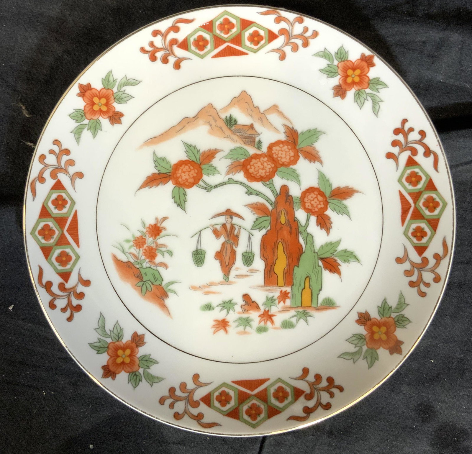 Antique Imari Porcelain Ceramic Plate: Antique Asian porcelain decorative arts, asian arts and crafts, tabletop decor, tableware, in tones of saffron and greens white background, woman carrying baskets or water pail with mountains and gard