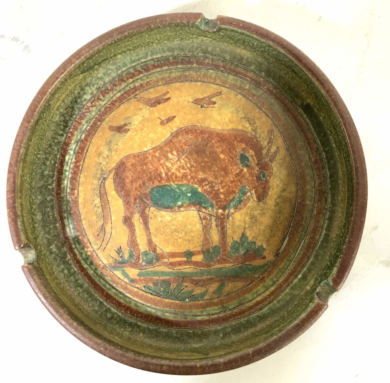 Vintage Italian Ceramic Vessel w Bull: Hand crafted handed painted ceramic ashtray, decorative object, circular dish, textured and painted in earth tones, folk art scene of bull in field, measures diameter app 9 inches ht 2 inches, signed