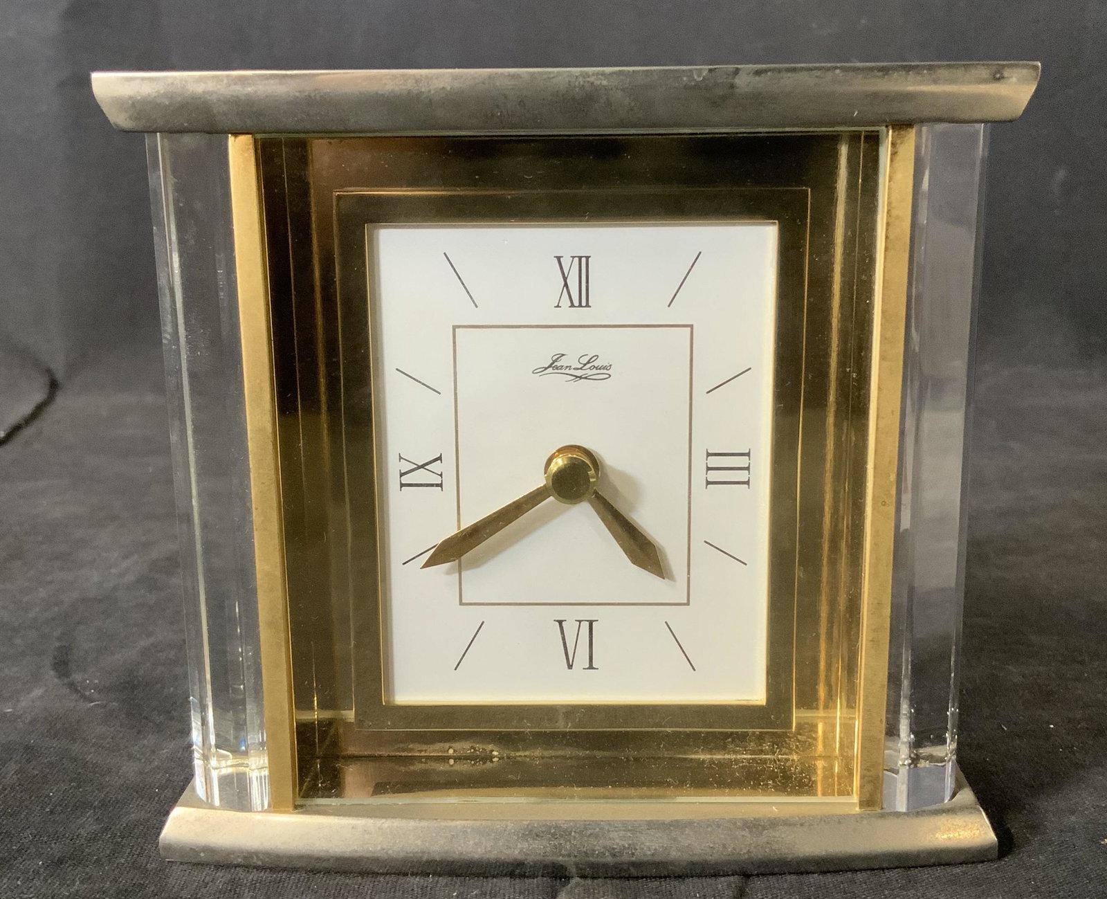 JEAN LOUIS Table Desk Clock: JEAN LOUIS Table Clock, inscription reads ‘Jean Louis’, measures 4 3/8 inches tall x 4 3/4 inches at widest point, some surface wear and tarnishing to clock but overall in good condition, Property