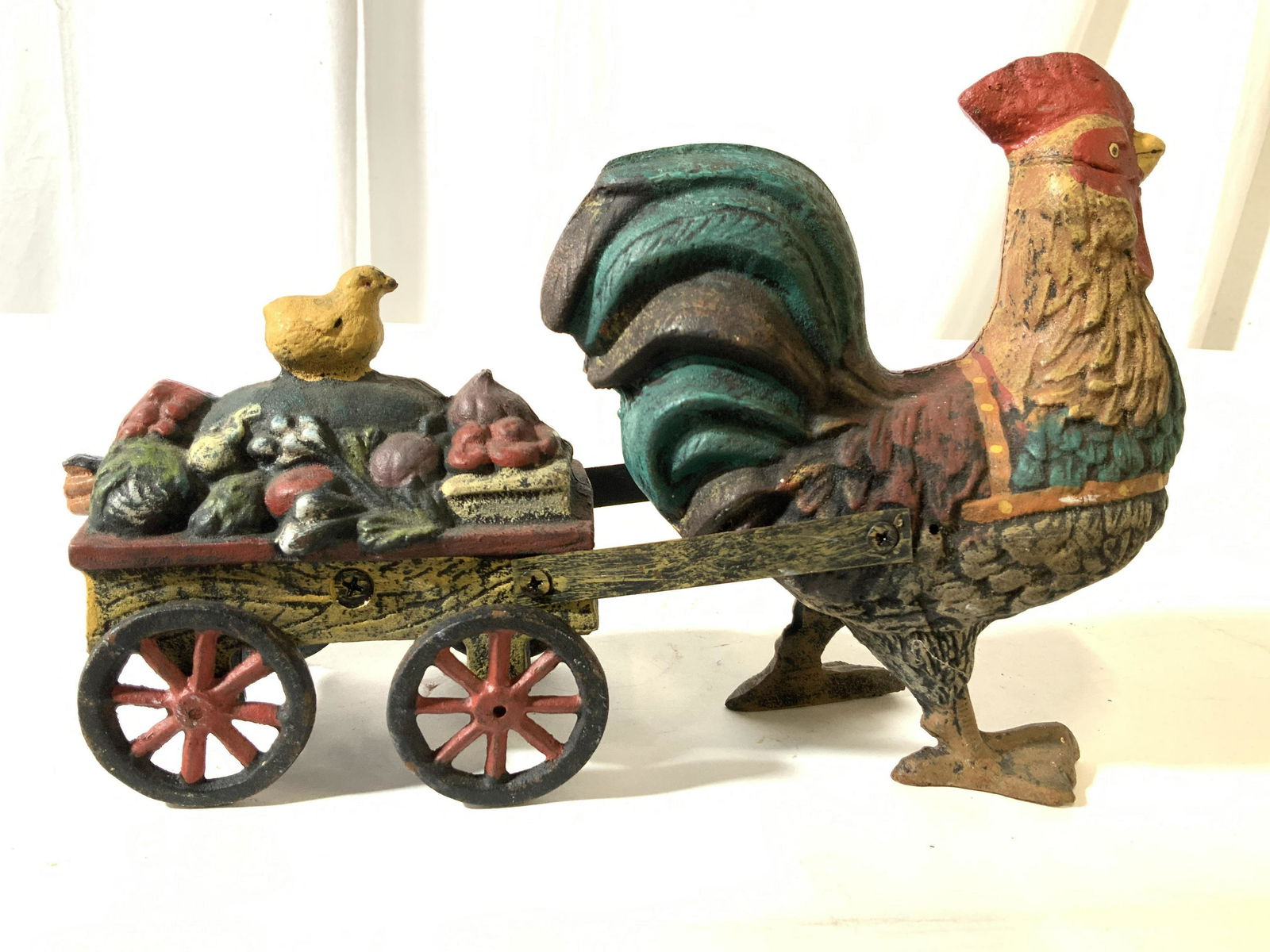 Antique Iron Rooster Pulling Wagon W Chicks Toy: Antique cast iron toy or doorstop with moveable parts, wheels turn, wagon has articulated joints to pull mechanism which attaches to chicken at articulated joint, painted cast iron rooster or chicken