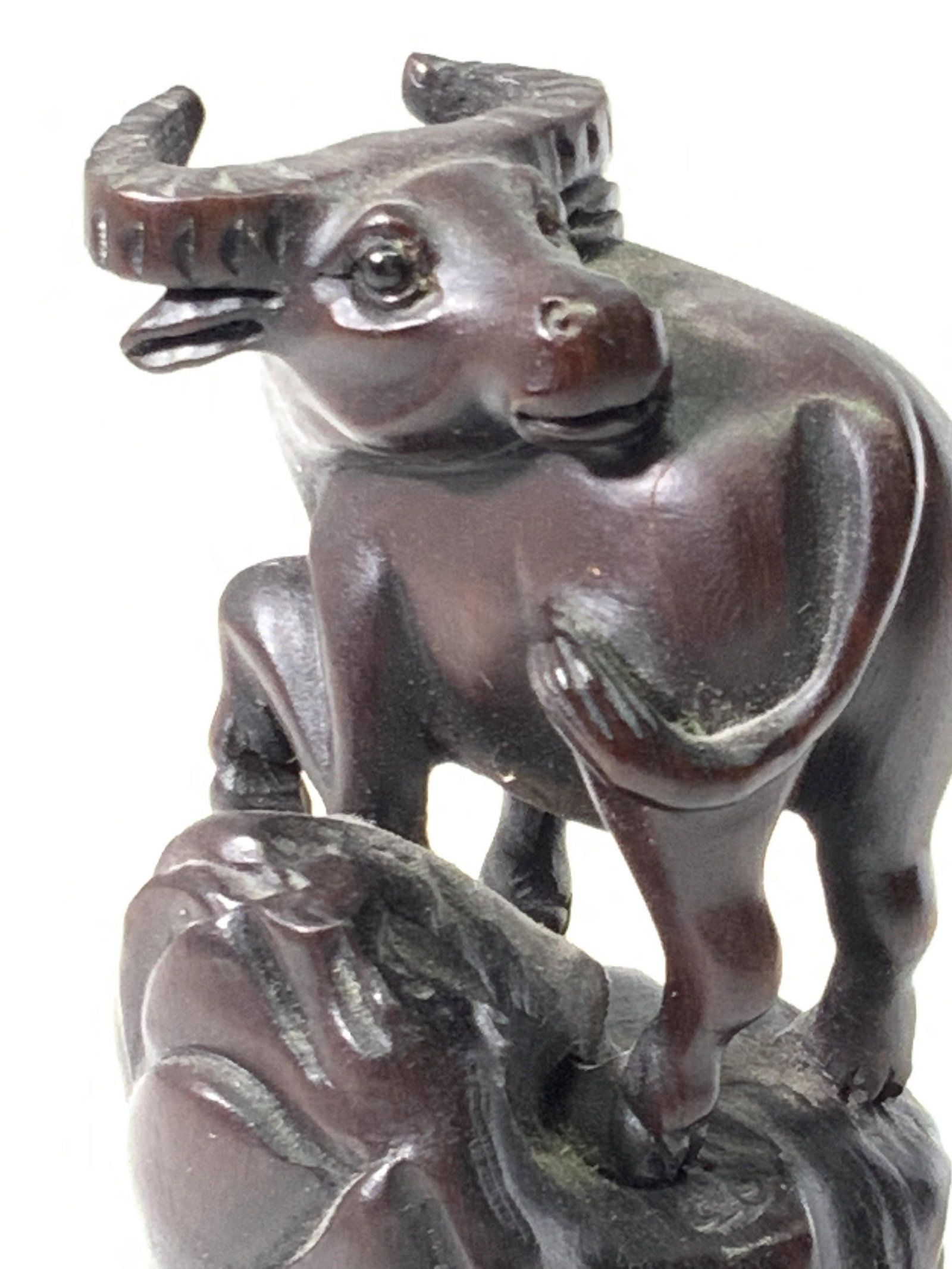 Antq SIGNED Asian Carved Wood BUFFALO OX NETSUKE: Antique dark brown wooden netsuke depicting a Buffalo Ox standing on a hill. Wood is very dark, rich brown. This is a kataborinetsuke, a sculptural netsuke. The netsuke stands on it’s own and featur