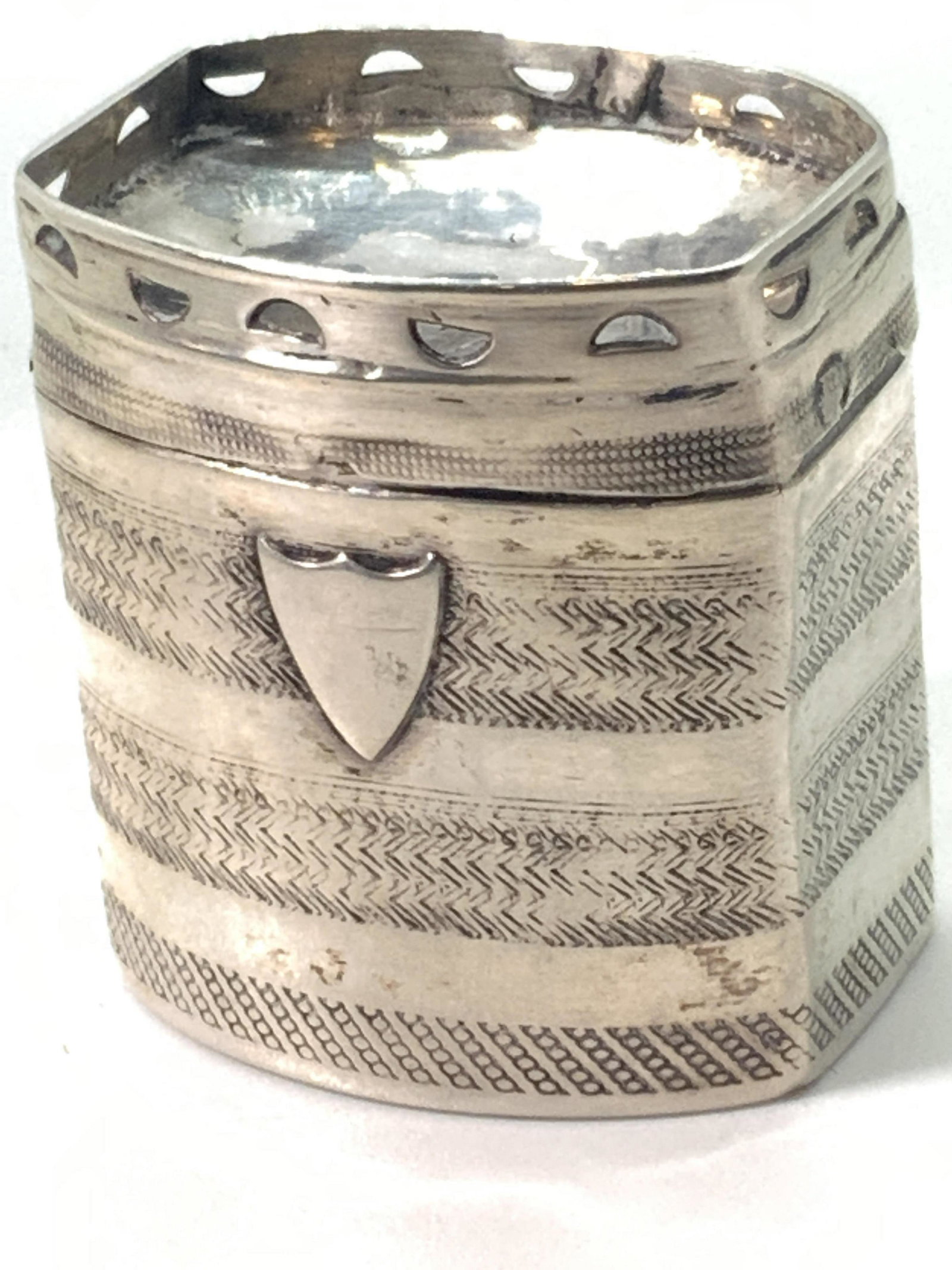 Antique Dutch Sterling Silver Crest Pill Box: An antique (circa 1850) Dutch sterling silver pill box. The base and lid are connected via hinge hardware. The exterior detailing features intricately etched patterned band designs. The lid features a
