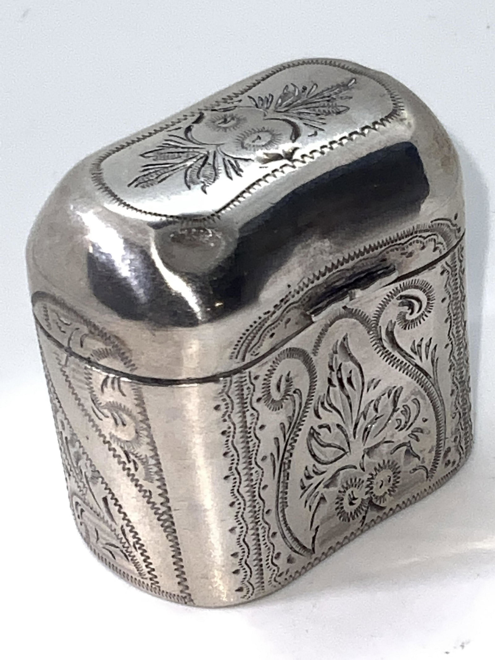 Antique Dutch Sterling Silver Etched Pill Box: An antique (circa 1861) Dutch sterling silver pill box. This piece has hinge hardware that connects the base to the lid. The exterior detailing features intricately etched floral motif designs. Hallma