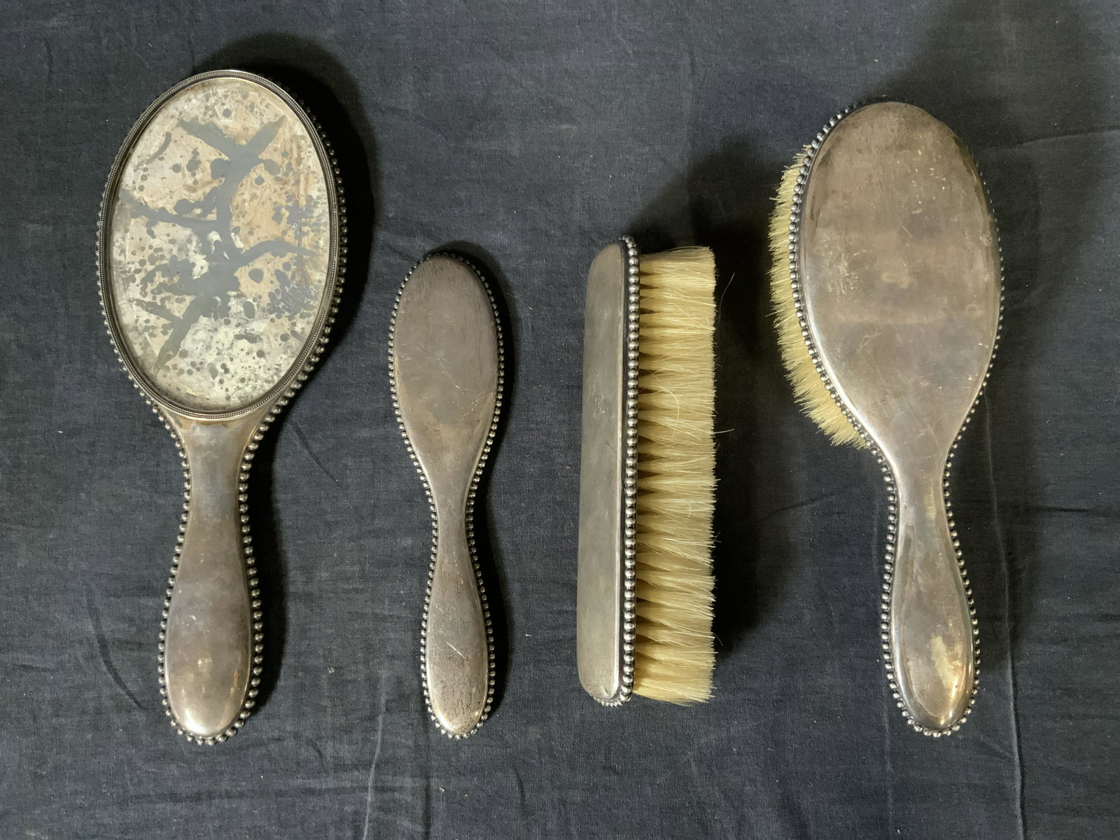 Lot 4 Antique Sterling Silver Vanity Accessories: Lot 4 Antique Sterling Silver Vanity Accessories, marks to pieces, silver bead trim detailing, mirror has original glass, measures 10 5/8 x 4 1/8 inches wide, smallest handle measures 7 5/8 x 1 7/8 in