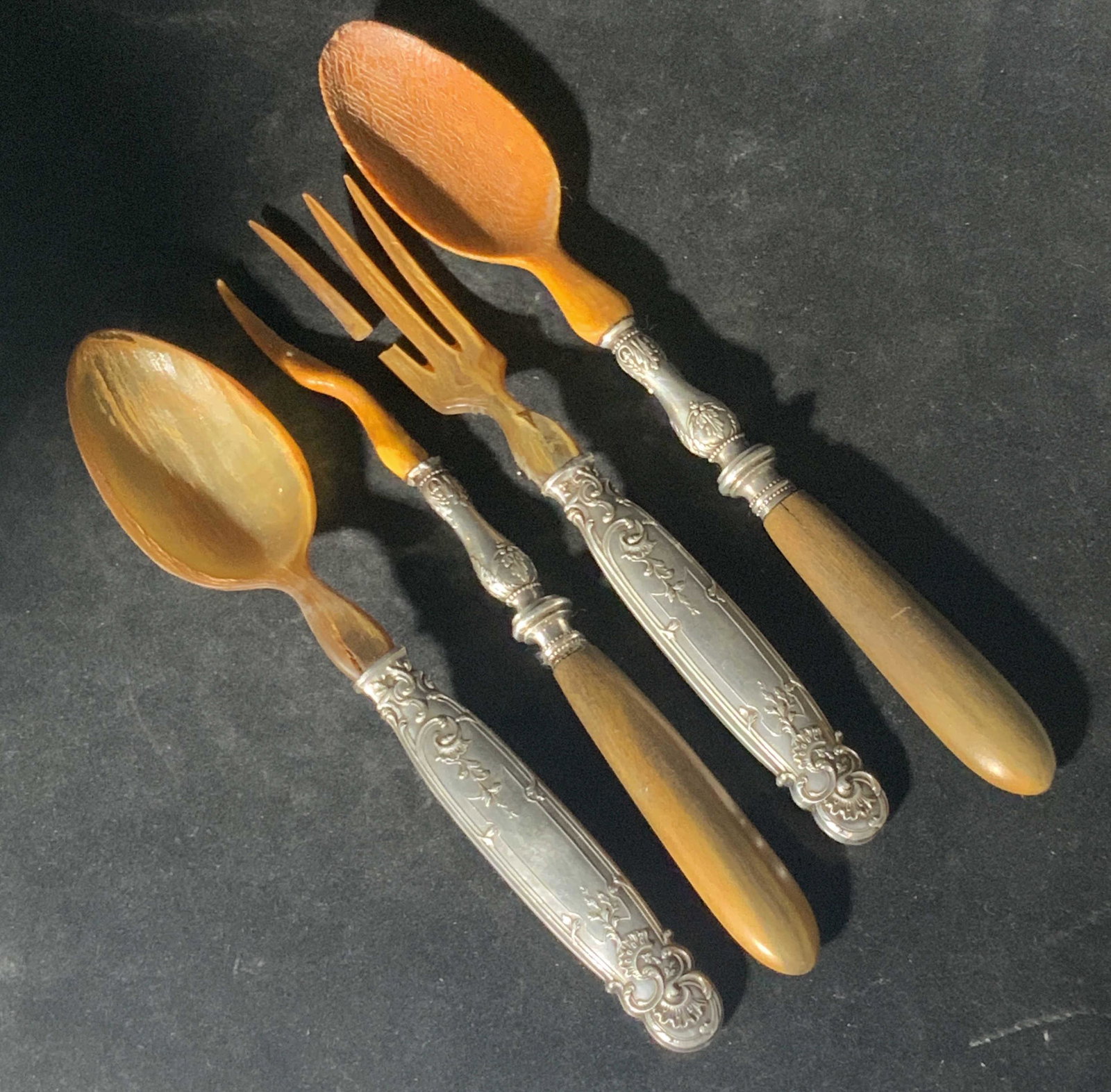 Lot4 Vntg Sterling Silver, Bakelite, Wood Utensils: Four pieces of vintage sterling silver, wood, and bakelite utensils. Two serving spoons, two serving forks. Each match the other. Both forms need repair to their prongs. Spoon has a crack. Sterling si