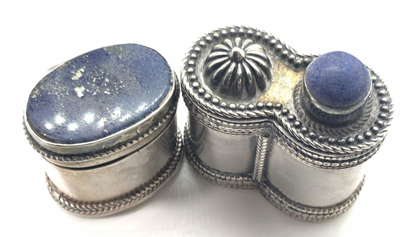 Set2 Vntg Sterling Natural Blue Stone Pill Boxes: Two vintage sterling silver double and single cylinder lidded pill boxes. Both possess a lid and base that fit together. One hinged. Polished silver exterior. Etched and embossed details on the lid an