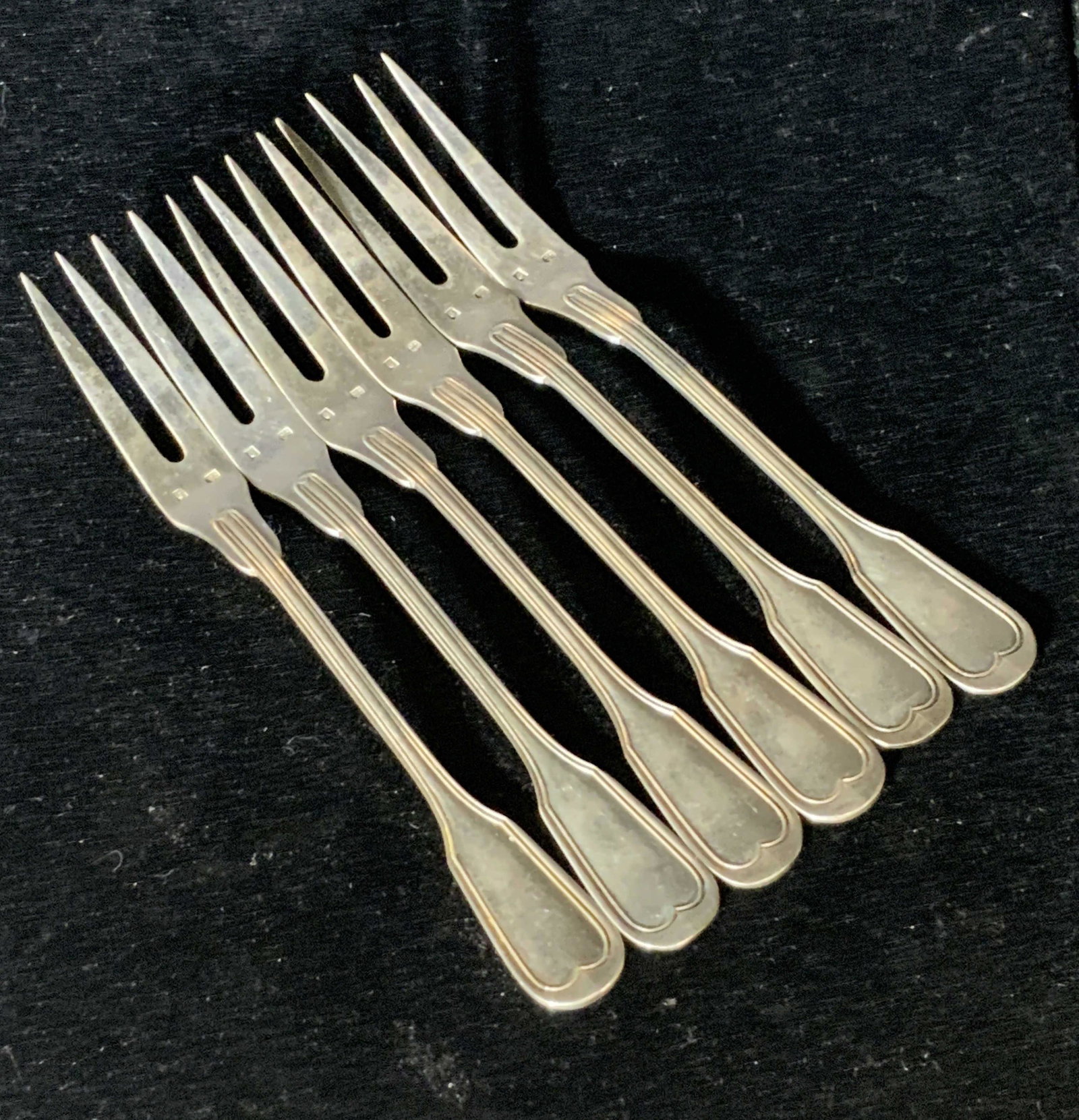 Set 6 Silver Plated French Hors D’oeuvres Forks: Six silver plated hors d’oeuvres forks crafted by a French maker. Each fork is hallmarked / trademarked beneath the prongs. Forks possess two prongs. Possibly vintage. Approx. 5.5 x .5 in. Property 
