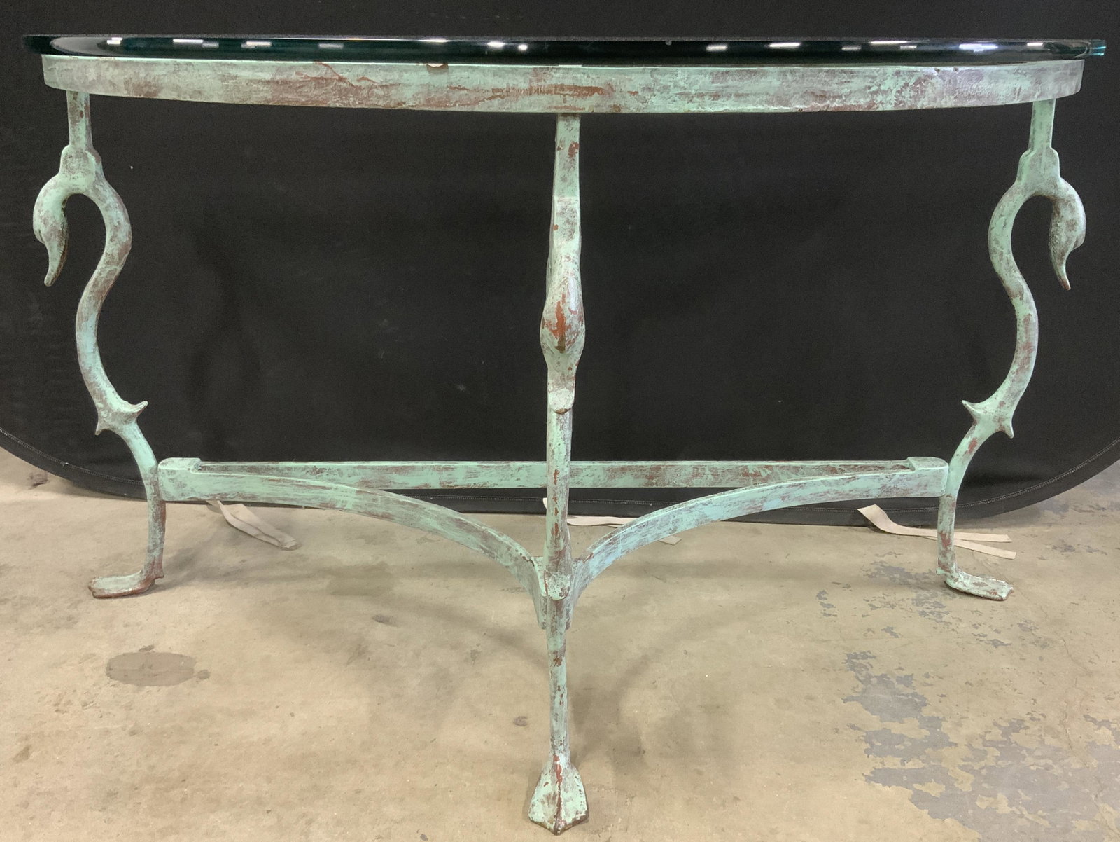 Vintage Demilune Glass Topped Console Table: Vintage glass topped console table. Demilune styled, legs resemble ducks bowing their heads, each of the tables feet resemble a webbed ducks foot. Table frame is metal and colored in a verdigris tone 