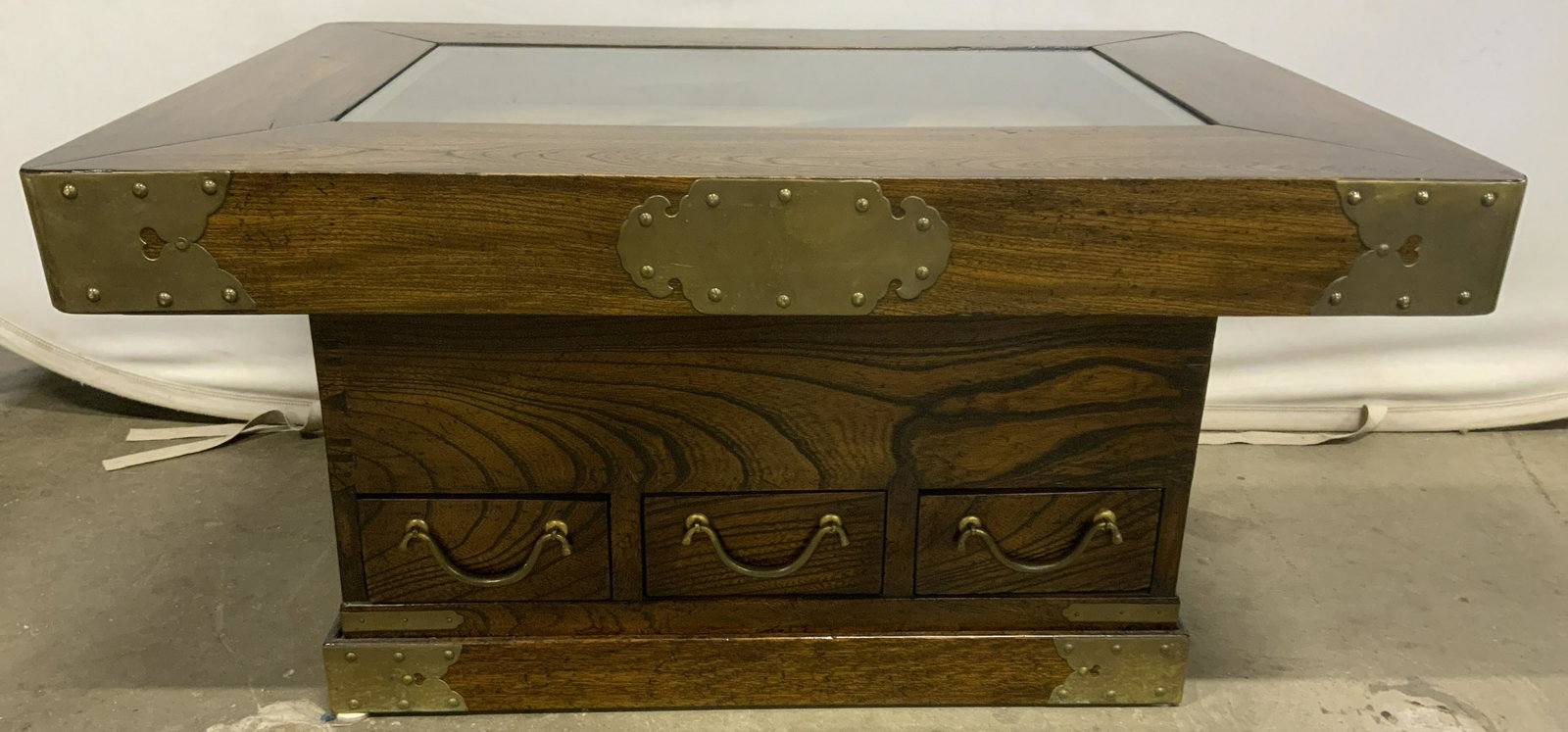 Vintage Indonesian Glass Topped Display Table: Vintage Indonesian display table. Originally a brazier, it has been repurposed into a table. Tabletop joints as well as the corners of the base are secured with brass and brass nails. Drawer pulls are