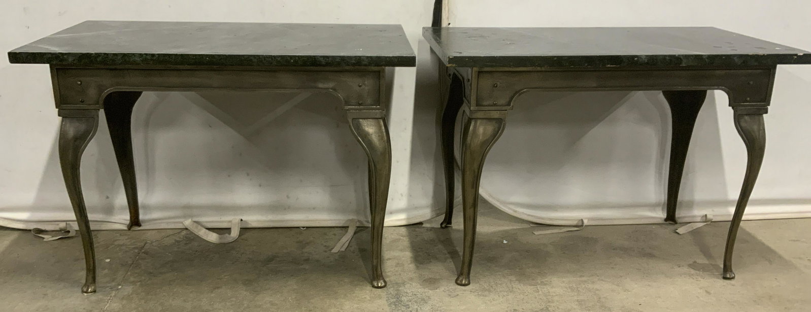 Pair Vintage Steel Console Tables w Wood Tops: Pair of wood topped console tables, possibly vintage. Table legs are cabriole, tabletop veneer resembles marble. Measures approx 30.75 inches H, 43.25 inches W, and 23.25 inches deep. Wear is consiste