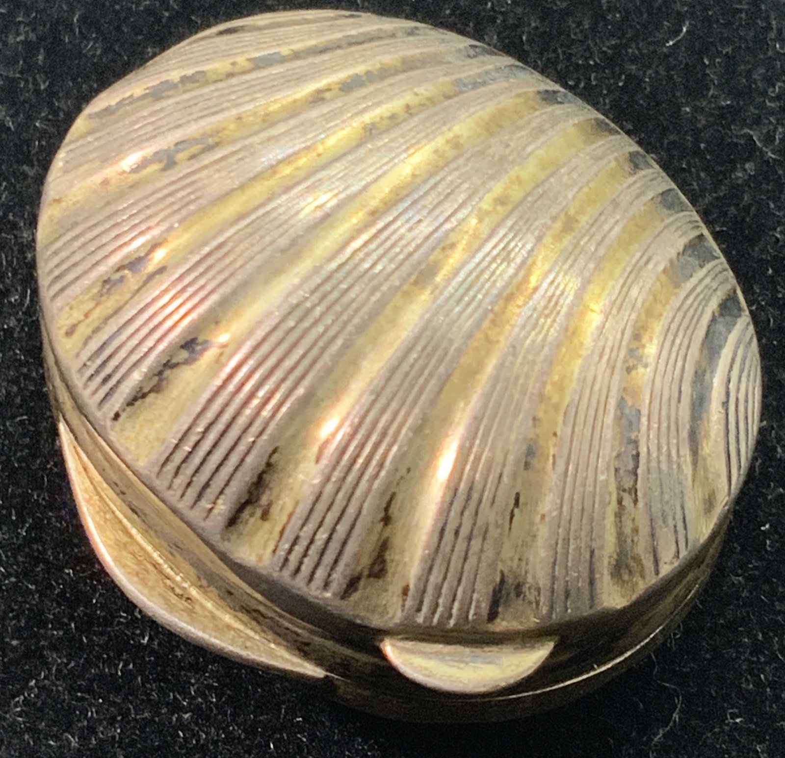 Vintage Sterling Silver Shell Form Lidded Pill Box: A vintage, possibly antique, sterling silver shell for pill box. The piece has etched designs that mimic the natural appearance of a shell. A gold wash covers most of the piece. The lid and base fit t