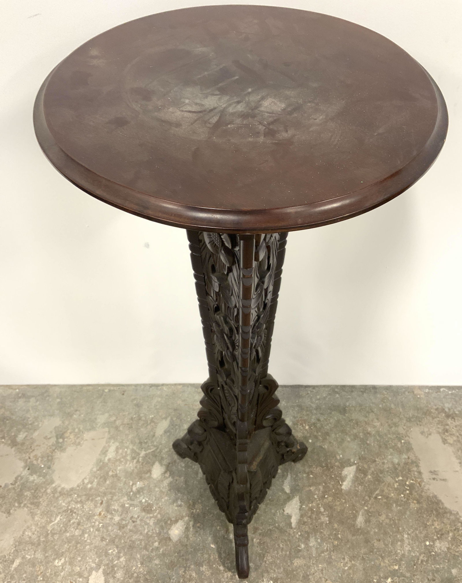 Vintage Intricately Carved Wooden Pedestal: Pedestal is vintage possibly antique. Piece contains intricately carved floral & leaf detail. Piece has c curve style feet. Pedestal top has circular shape. Piece measures approx 40 inches tall 15 inc