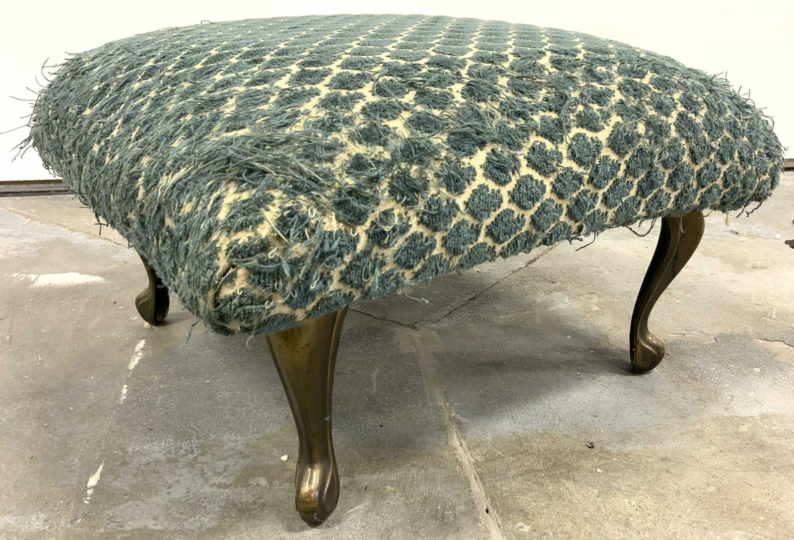 Vintage Brass Foot Upholstery Footstool: Footstool is vintage. Piece has 4 gold toned brass feet. Piece has cream & teal toned patterned upholstery. Footstool is possibly custom made. Piece measures approx 16 inches square 10 inches tall. Fo