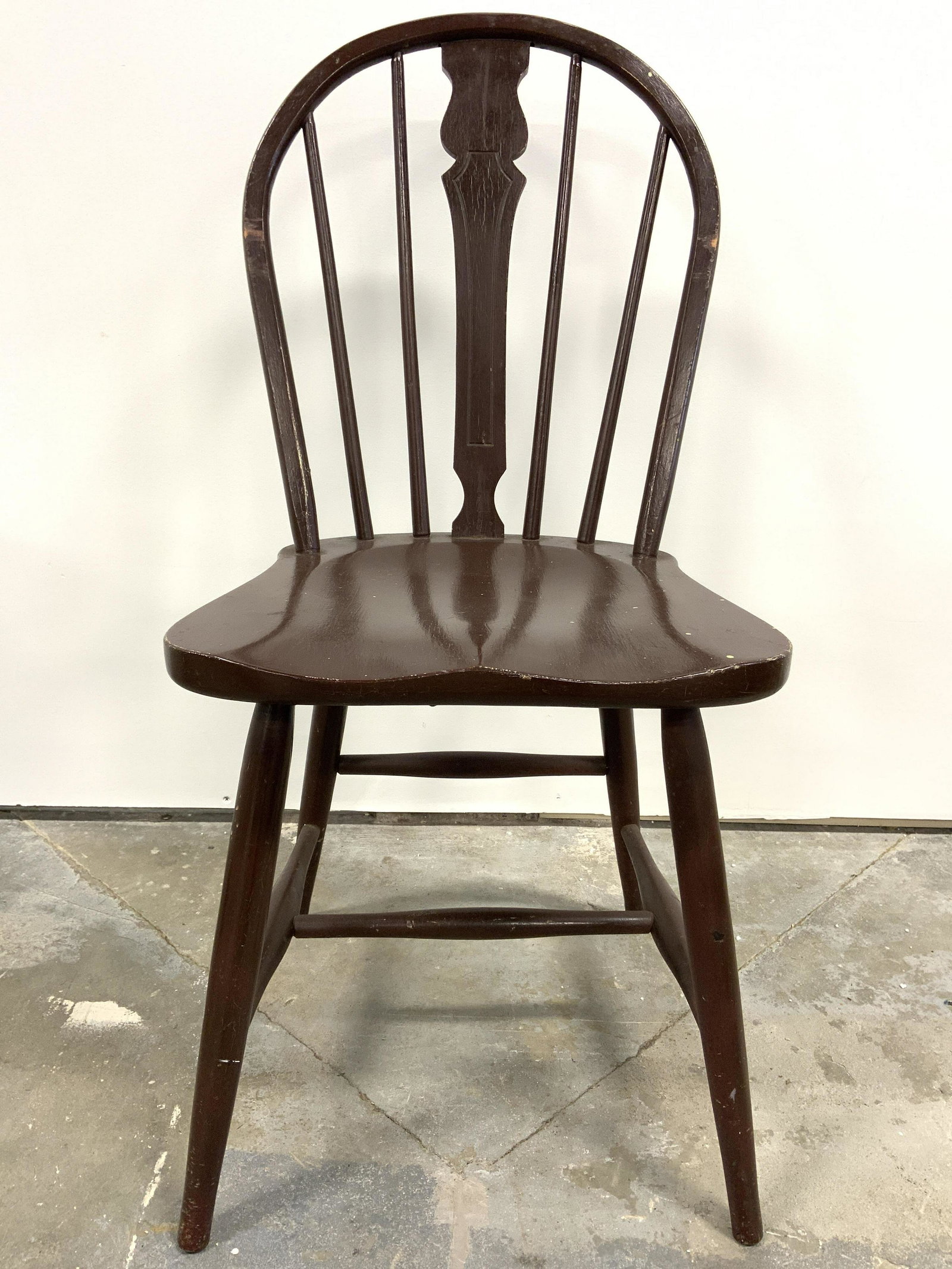 Vintage Wooden Spindle Back Side Chair: Chair is vintage possibly antique. Piece is wooden & brown toned. Chair has spindle backrest with carved wooden center. Chair legs have stretcher in between. Piece measures approx 34 inches tall 16 in