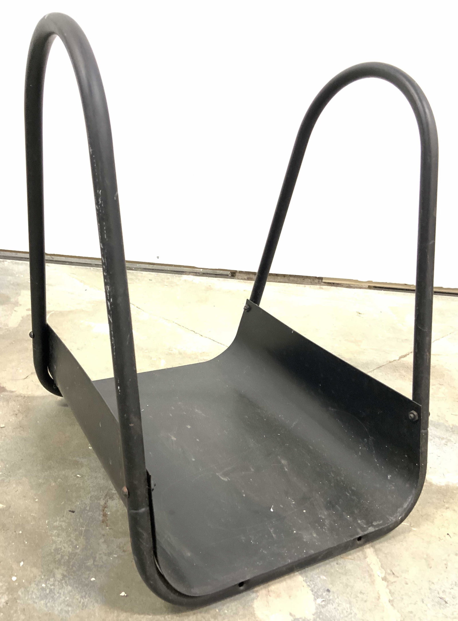Black Metal Firewood Holder W Handles: Firewood holder is black toned and metal. Piece appears to be vintage. Piece has 2 handles 1 on each side. Piece measures approx 17 inches tall 13 inches wide 14 inches deep. Firewood holder, fireplac