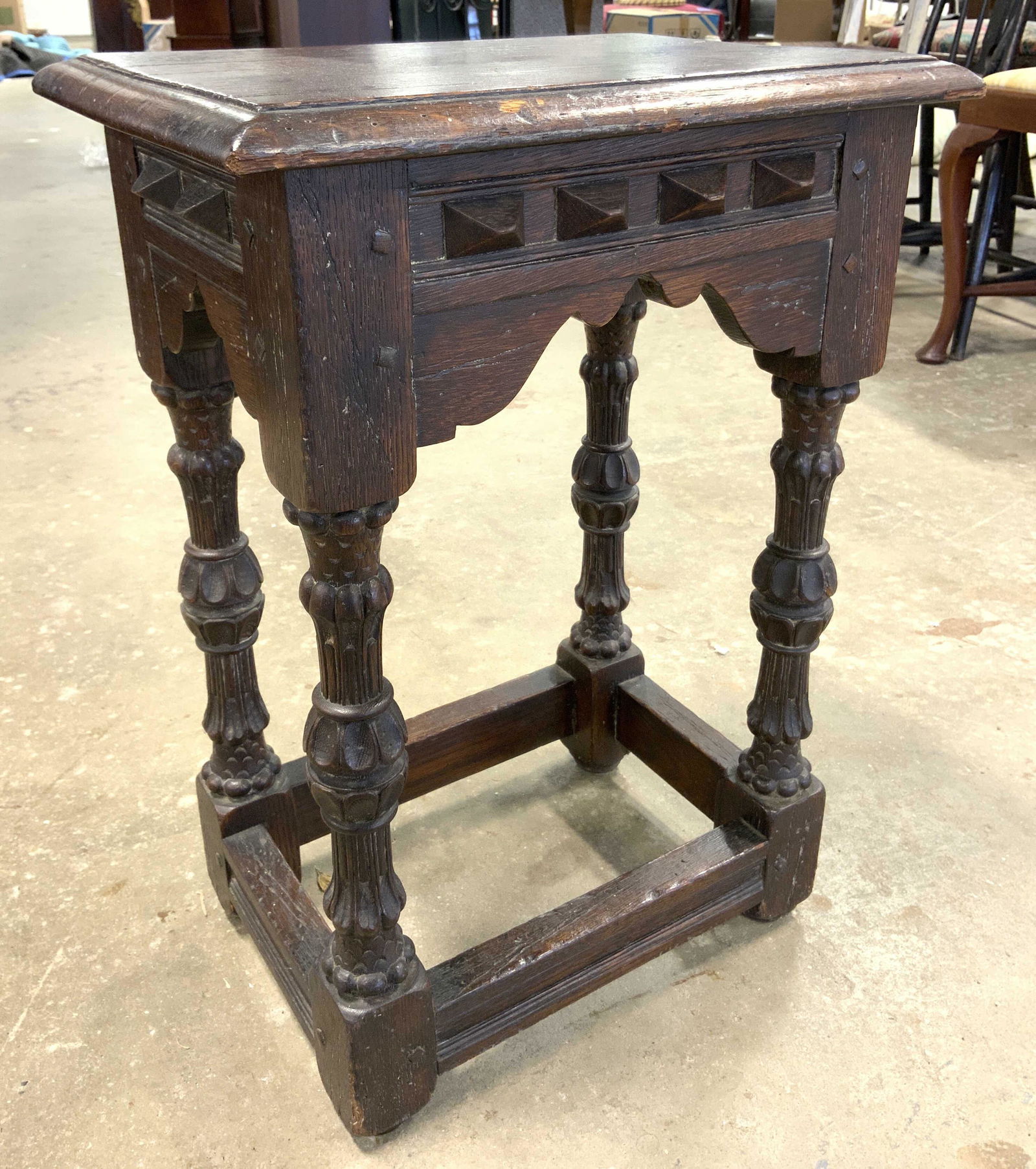 Vintage Hand Crafted Carved Wooden Side Table: Side table is vintage possibly antique. Piece appears to be hand crafted. Contains intricately carved legs with stretchers in between. Piece measures approx 23 inches tall 16 inches wide 12 inches dee