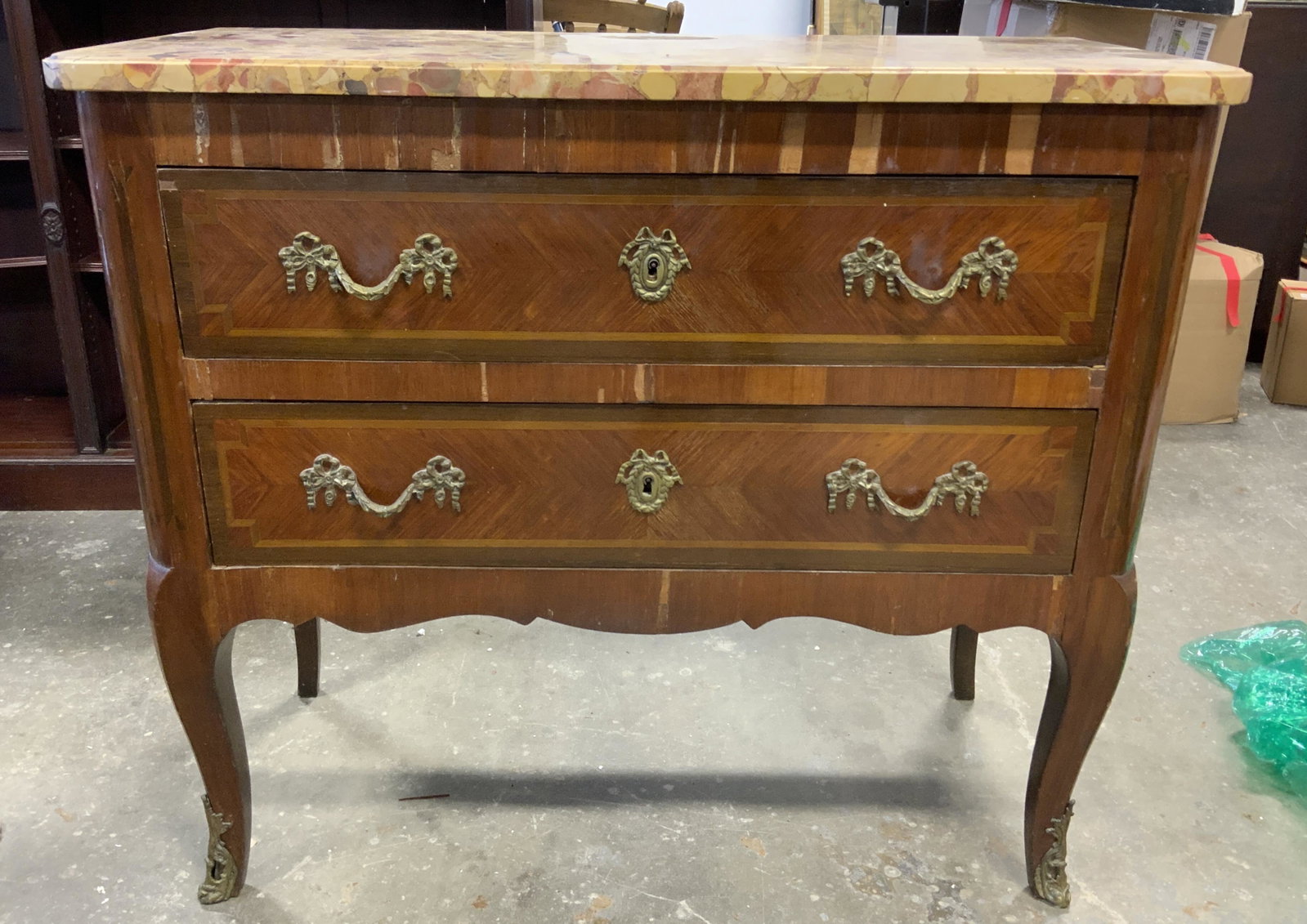 Antique BEDEL & CIE Marble Topped Console Table: Antique, French, wooden dresser. Drawers and legs are decorated with cast brass detailing, resembles ribbons and bows. Both drawers are equipped with a brass lock, the key is absent. Label beneath mar