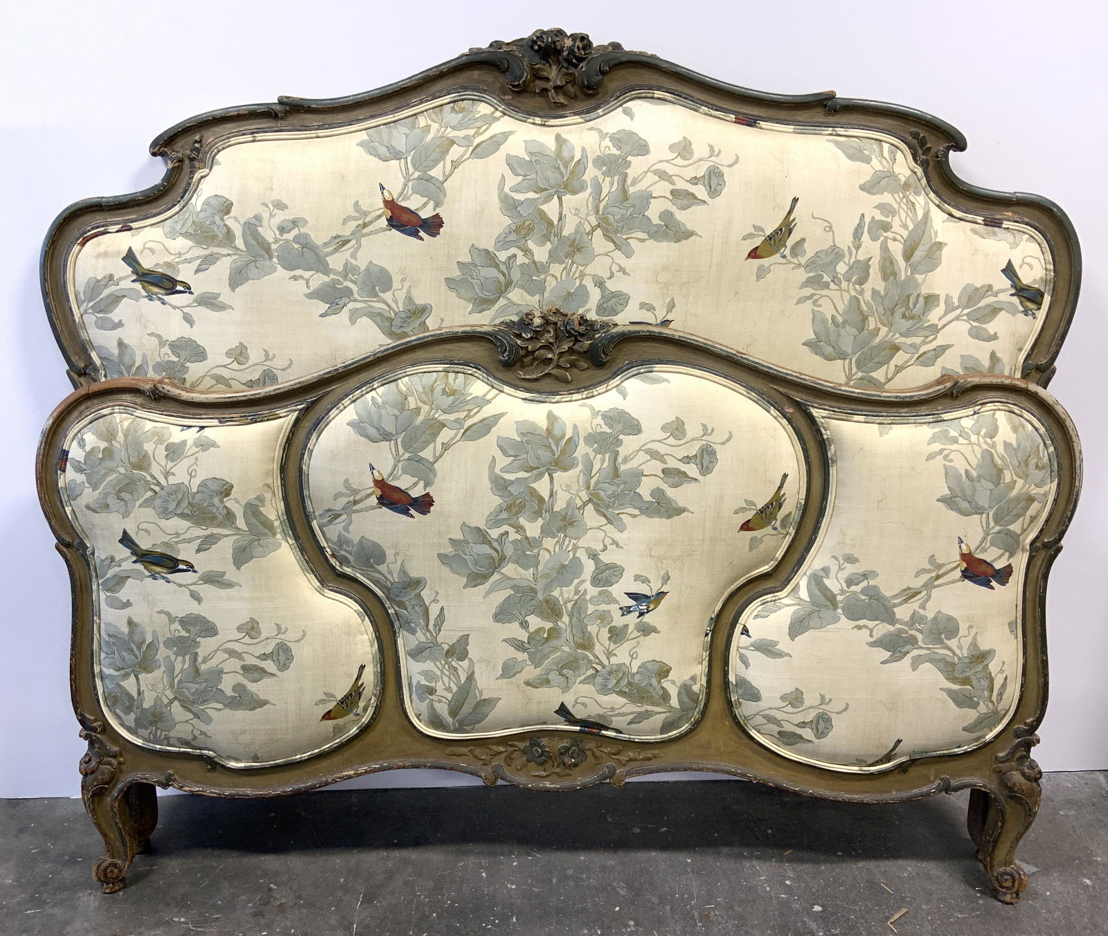 Vintage Custom Made Upholstered Head & Footboard: Lot includes 1 headboard & 1 footboard. Each are vintage possibly antique. Each have upholstery with multi toned floral leaf & bird detail with double welting at edges. Each have carved wooden floral