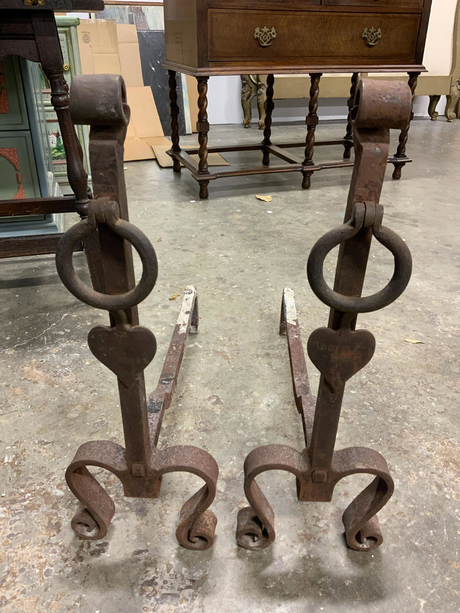 Antique Cast Iron Andirons, Fireplace Accessories: Pair of antique andirons, crafted from cast iron. Measures approx 24 inches H, 23 inches long. Legs are scrolled. Wear is consistent with age and use. Property of Janine Metz Social Secretary to the D