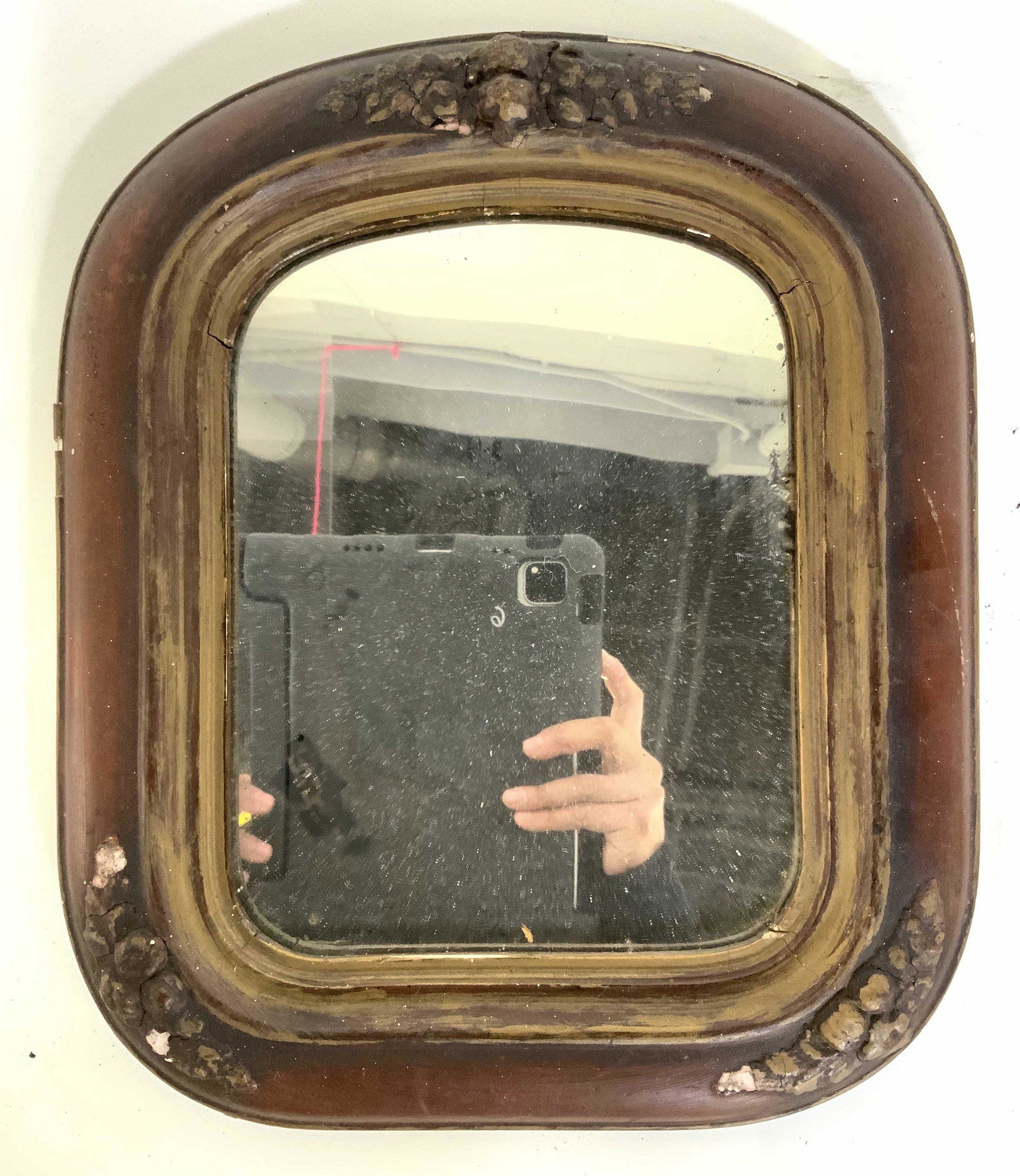 Antique Wood Frame Wall Mirror: Wall mirror is antique. Frame is wooden. Contains beveled gold toned floral and leaf detail. Piece has deep brown toned frame. Piece measures approx 14 inches tall 12 inches wide. Mirror, vintage mirr