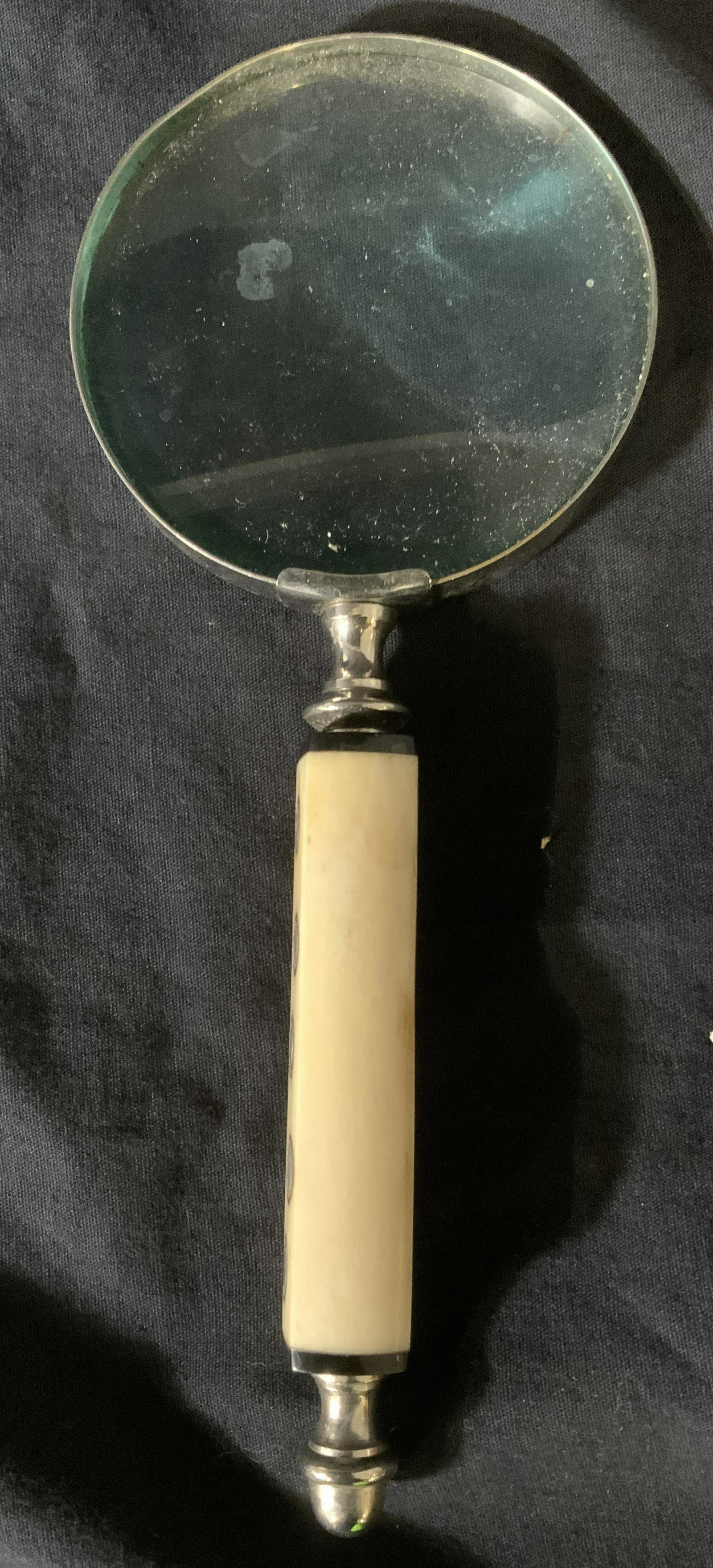 Vintage Magnifying Glass W Carved Bone Handle: Magnifying glass is vintage. Piece has cream toned carved bone handle. Underside of handle has silver toned metal finial structure. Magnifying glass, vintage magnifying glass, magnifying glass with bo