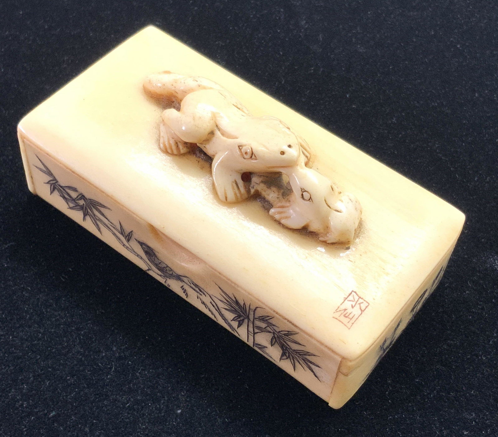 ASIAN CARVED ANTQ SIGN FROG SNUFF BOX, Collectible: A vintage, possibly antique, precisely incised Asian snuff box depicting two frogs on the lid. This collectible piece is crafted from bone and features etched foliage and birds along all sides, and tw