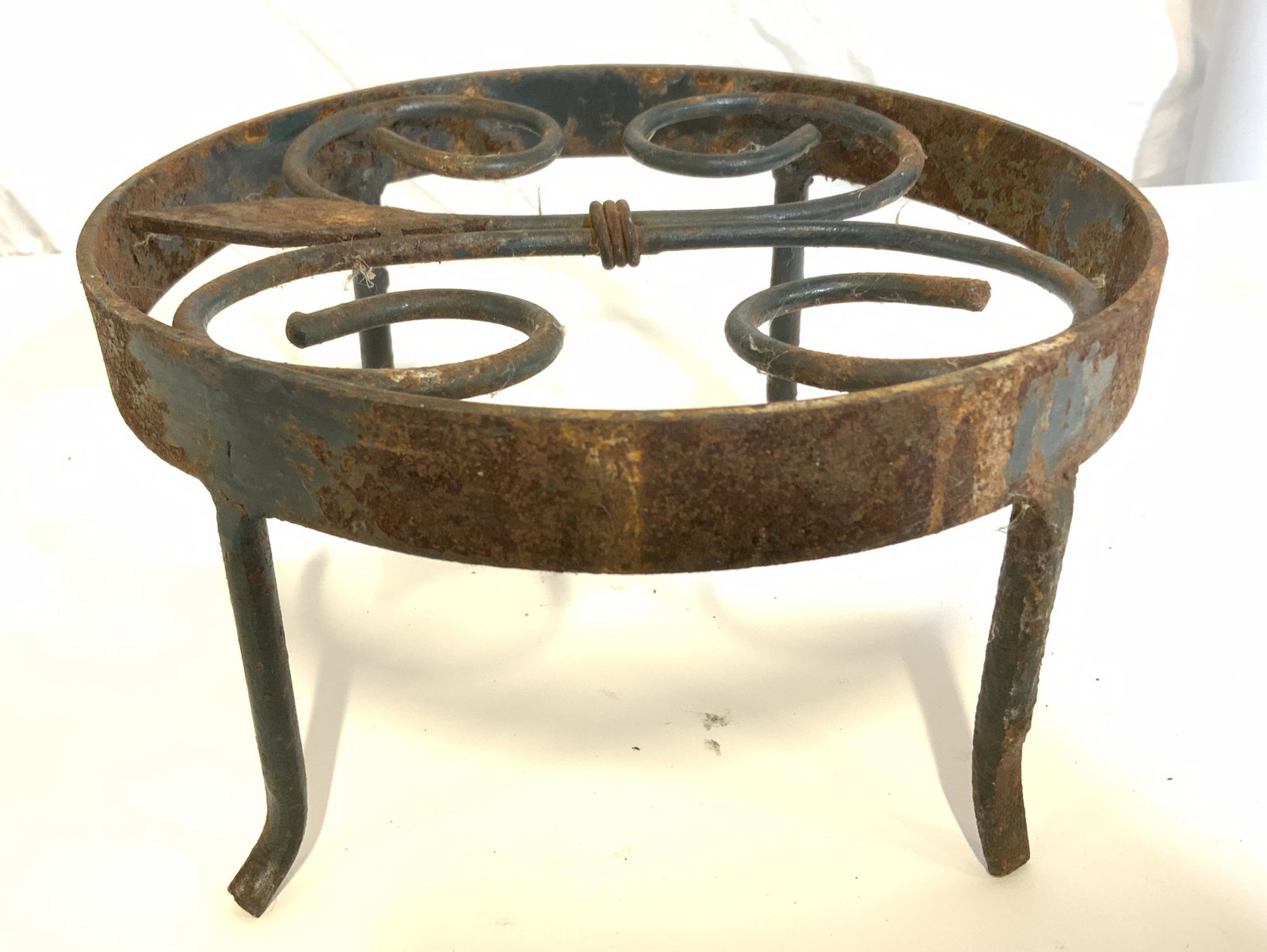 Vintage Wrought Iron Trivet: Vintage, possibly antique, wrought iron trivet. Four legged trivet, Measures approx 4 inches H, 8 inches W. Property of Janine Metz estate, Social Secretary to British Royals the Duke & Duchess of Win