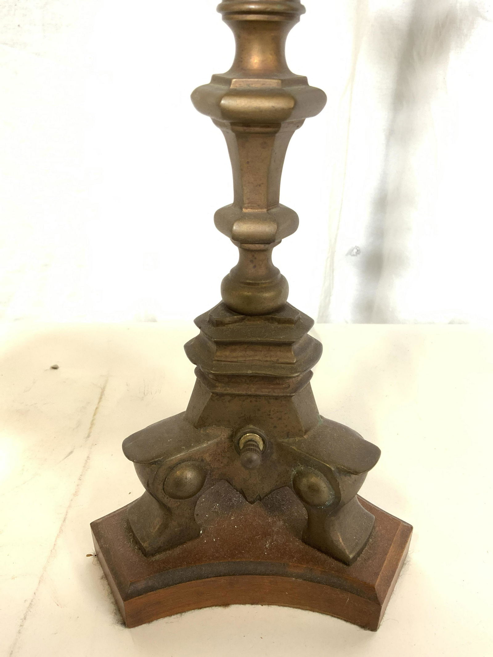 Vintage Brass Table Lamp W Toleware Shade: Lamp is vintage possibly antique. Piece is brass with carved wooden base. Lamp has twist switch. Top of piece has 2 bulb sockets. Shade is tole with black and gold tones. Lamp, vintage lamp, brass lam