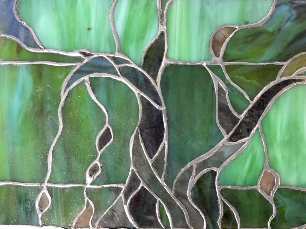 Vintage Stained Glass Panel Window Pane: Glass panel is vintage. Piece is stained glass with multi toned organically shaped detail. Piece has tones of green, amber, pink, yellow, & blue. Piece measures approx 23 inches long 8 inches tall. St