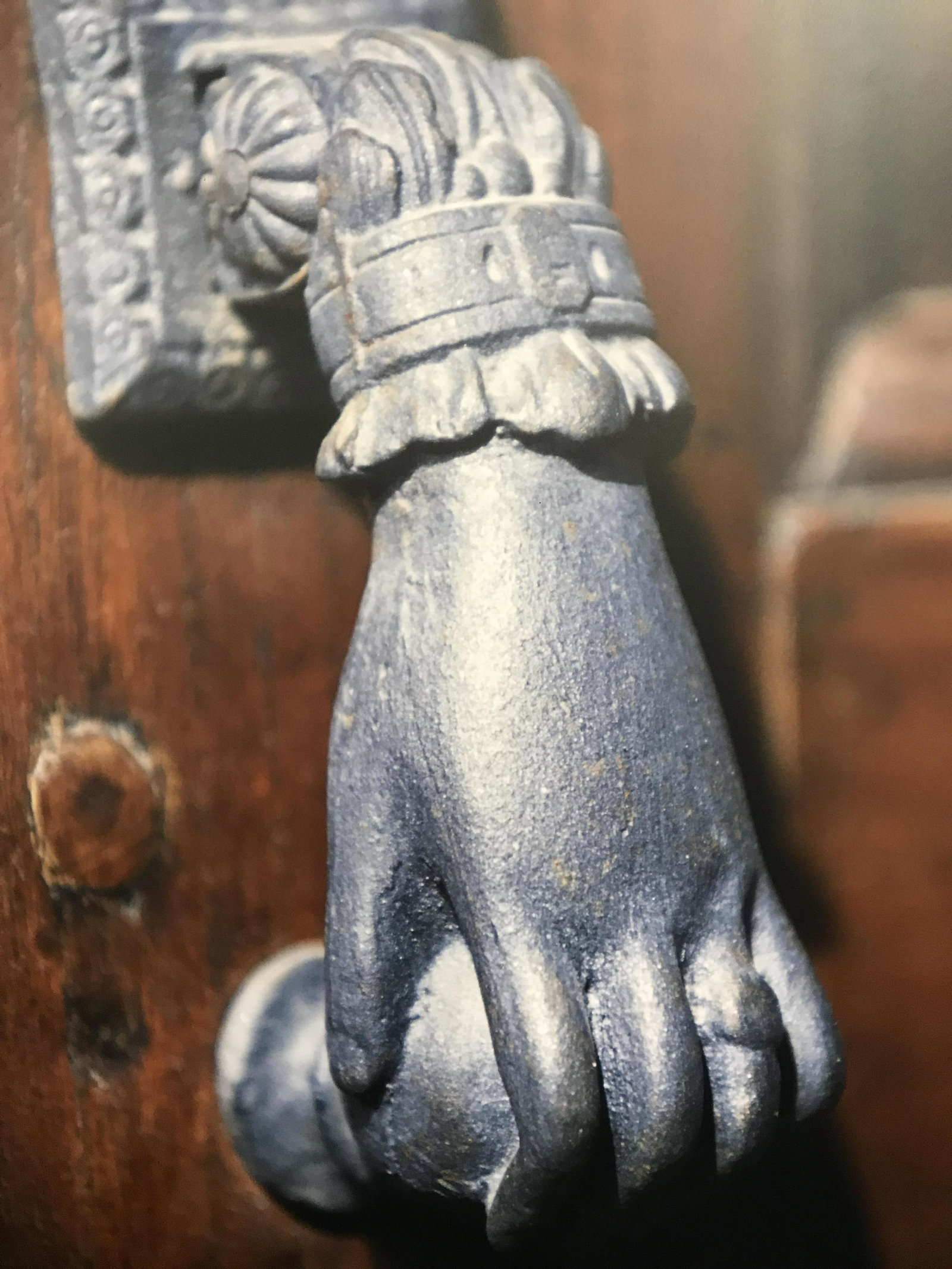 Photograph Printed on Wood of Hand Door Handle: Photograph printed on Wood of hand door handle, subject a photograph of a door handle shaped to appear as a hand reaching for a doorknob, measures 23.5 inches tall by 17.5 inches wide, not framed, han
