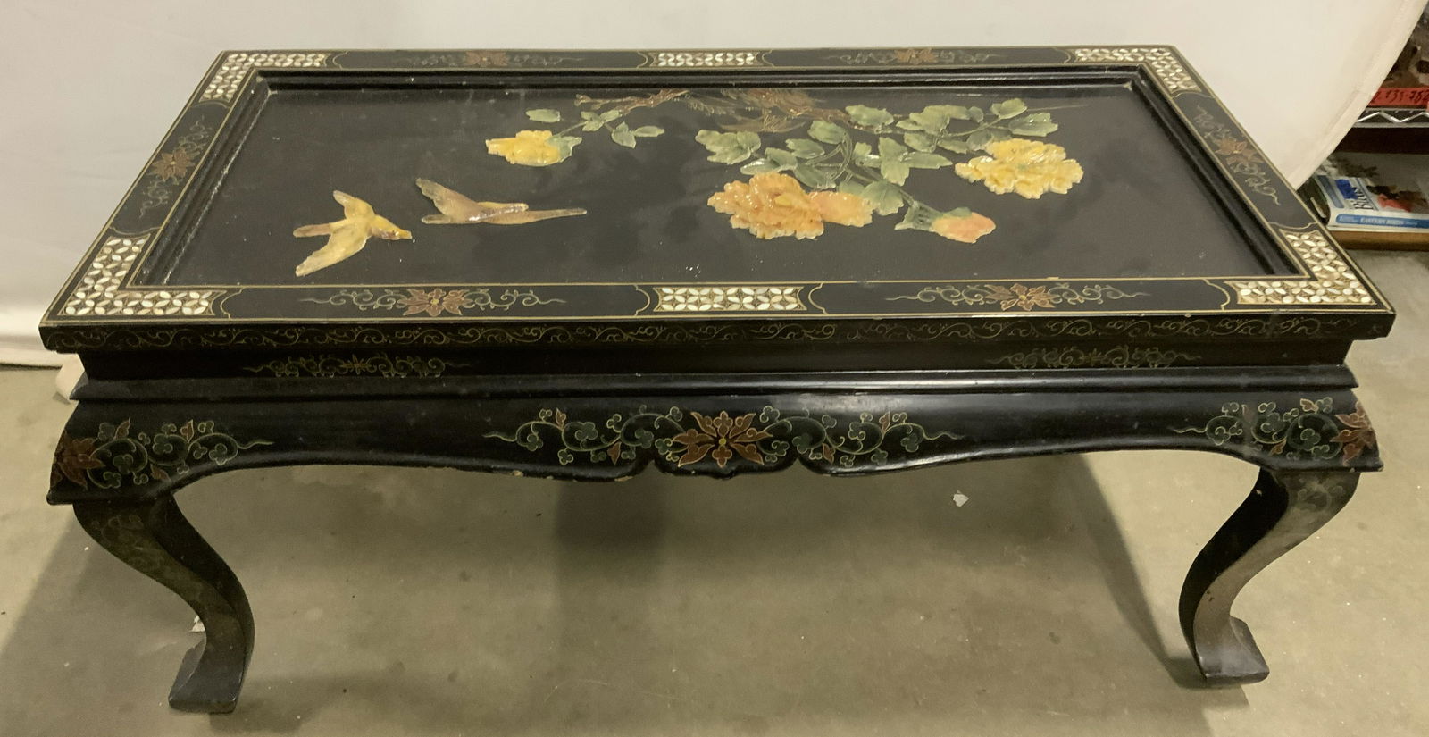 Asian Lacquer Coffee Table, Mother Of Pearl Accent: Coffee table is vintage possibly antique. Piece is black toned & lacquered. Piece has intricate mother of pearl detail. Table also has painted flora, vine & leaf detail, possibly hand painted. Tableto