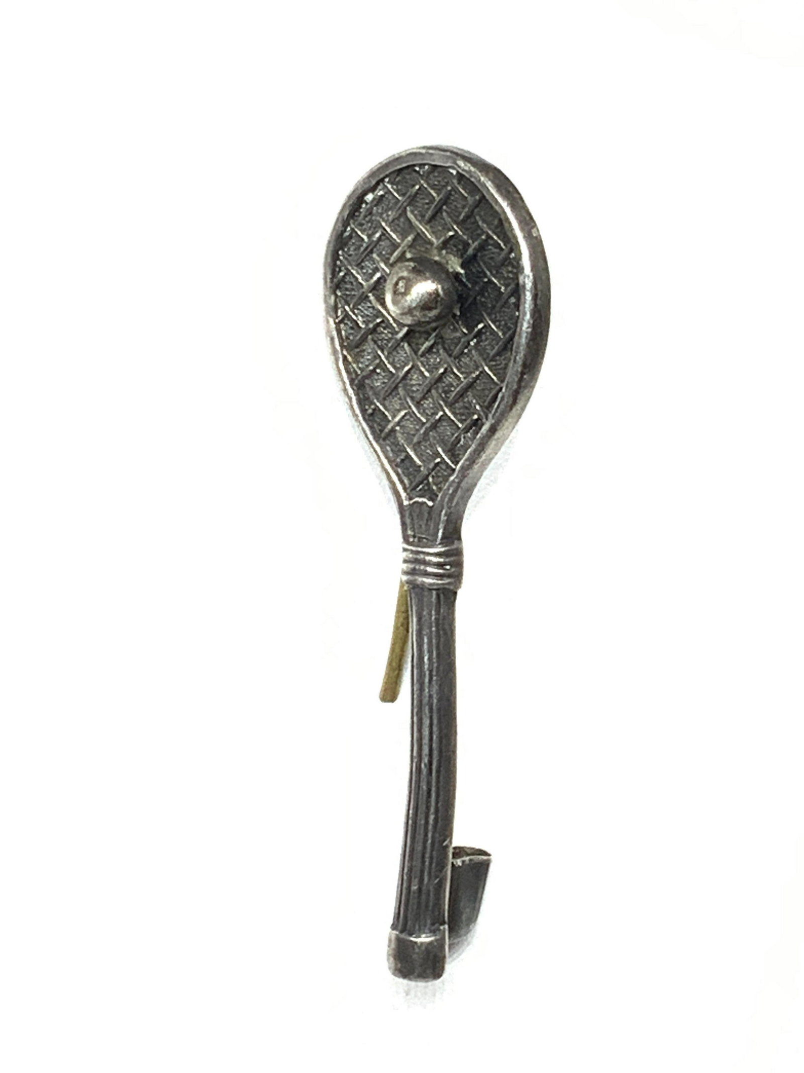ANTIQUE SILVER TENNIS RACQUET PIN: Antique silver racket with chased detail. Ball sits in center of racquet. Tested with puriTEST KIT, not marked. 1.75 in. L .12 ozt Property of Paris France Estate ANTIQUE BROOCH, antique tennis racque