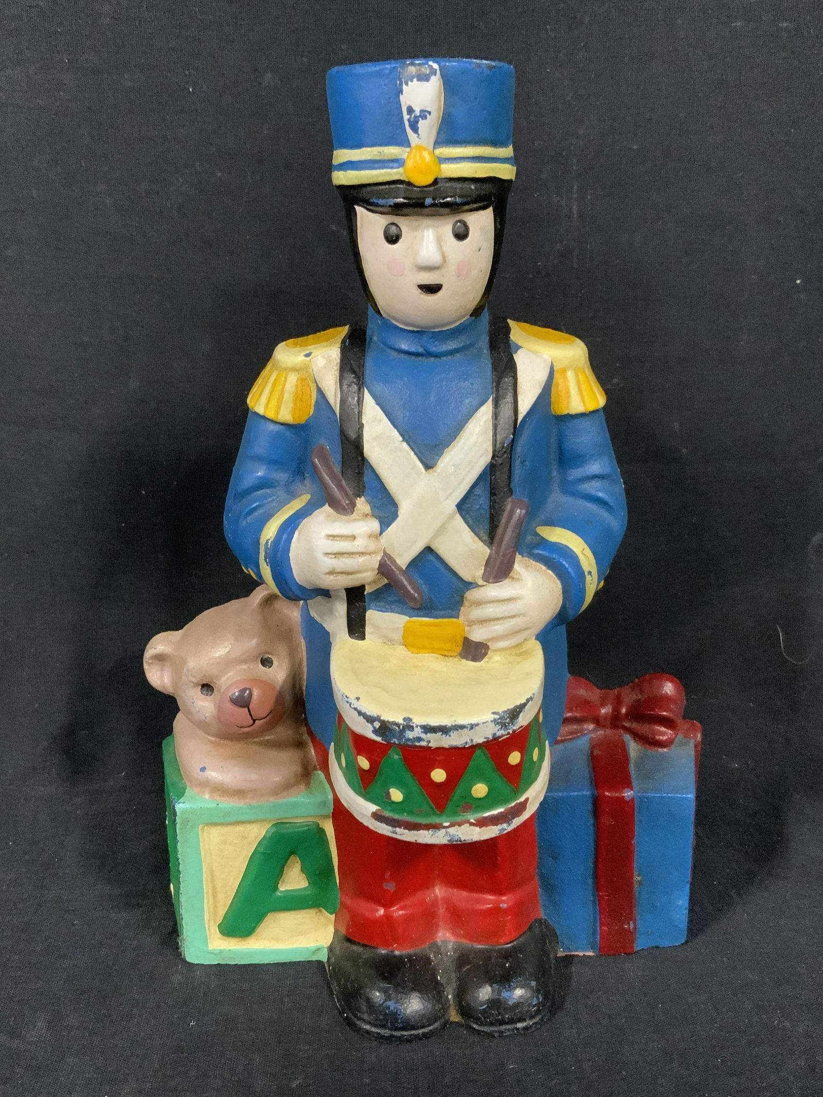Vintage Cast Iron Toy Soldier Door Stop: Tags cast iron door stop. Depicts a drumming toy soldier next to a teddy bear, wrapped present, and a toy block. Measures approx 9.14 inches H, and 6.25 inches W. Wear is consistent with age and expos