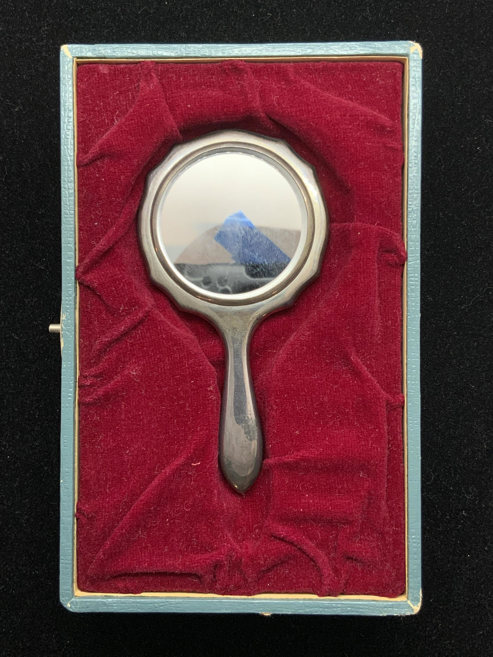 Vintage STERLING SILVER Handheld Mirror W. Case: A vintage handheld sterling silver mirror that comes with case. The exterior of the case is blue, and possesses mild wear due to it’s age. The interior of the case has a fitted red velvet style casi