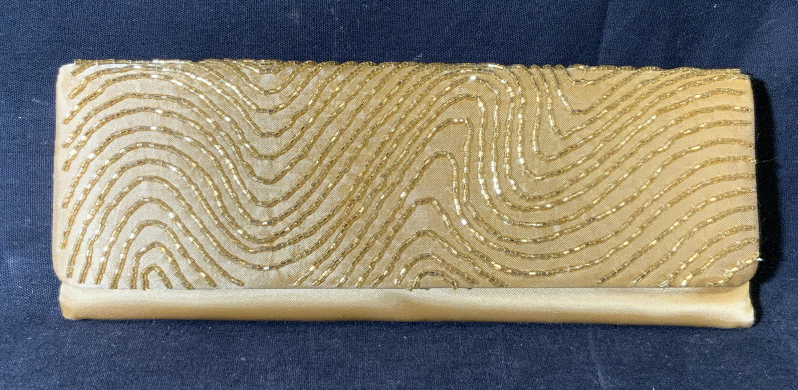 LA REGALE Beaded Clutch Bag: La Regale Beaded clutch bag, tags to interior reads ‘La Regale’ and ‘Made in China’, exterior covered in gold toned beads with a gold colored satin beneath the design, interior lined with the 