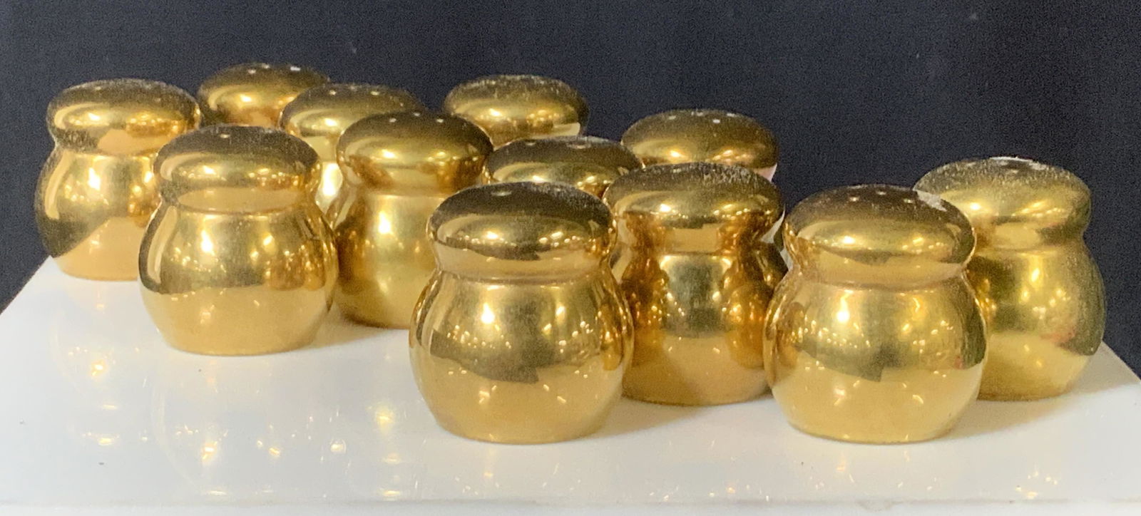 Set 12 FITZ & FLOYD Gilded Porcelain salt Shakers: FITZ & FLOYD solid gilded porcelain salt and pepper shakers , all Hallmarked ‘ copyright symbol FF’ in green ink. 1 1/4 x 1 1/4 in. Fitz and Floyd was founded in 1960 by Pat Fitzpatrick and Robert