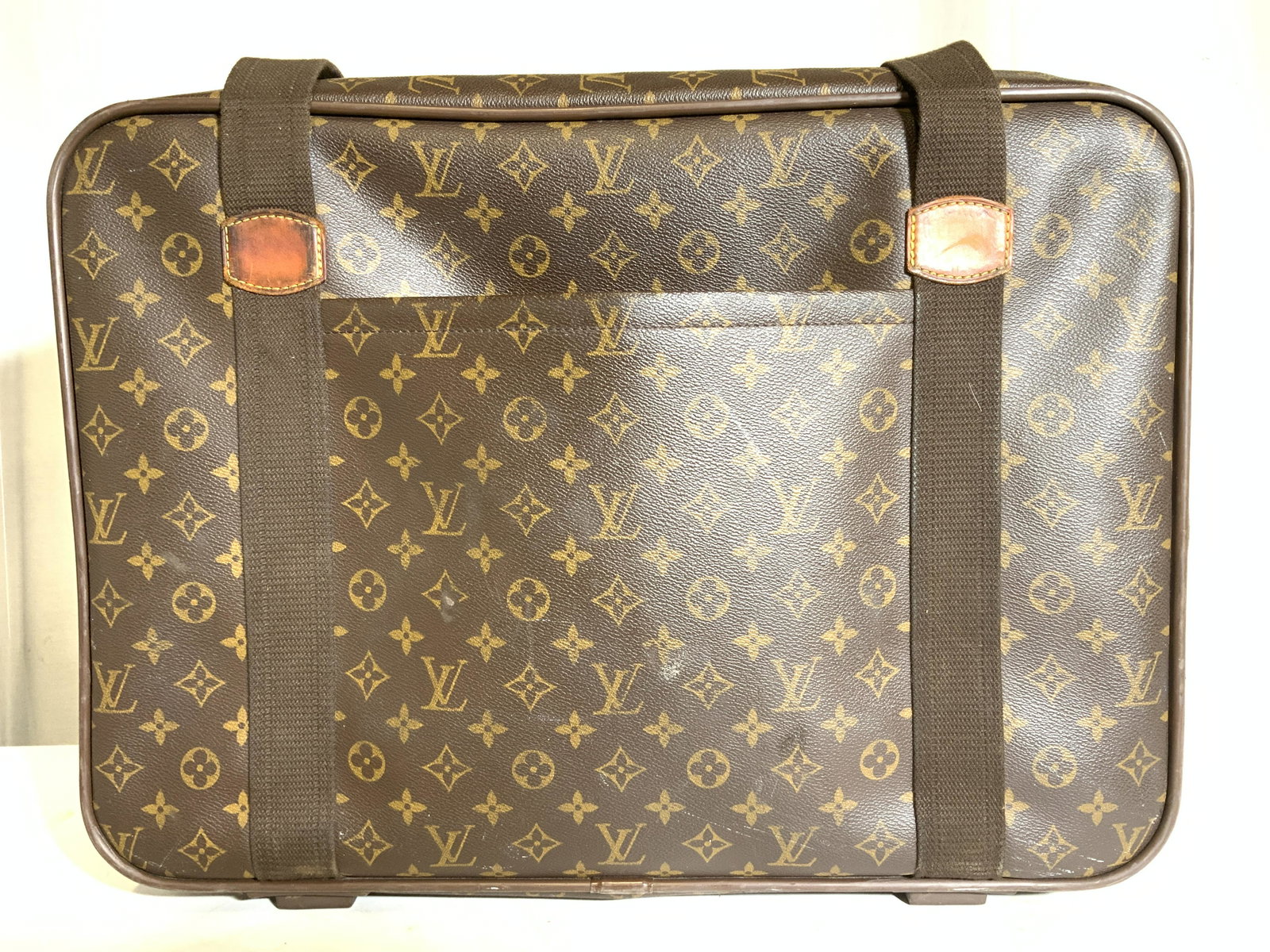 LOUIS VUITTON Luggage W Strap: Bag is marked for LOUIS VUITTON on gold toned metal strap edges. Piece has zippered opening with pocket inside. Luggage is possibly genuine possibly faux. Appears to possibly be leather. Piece measure