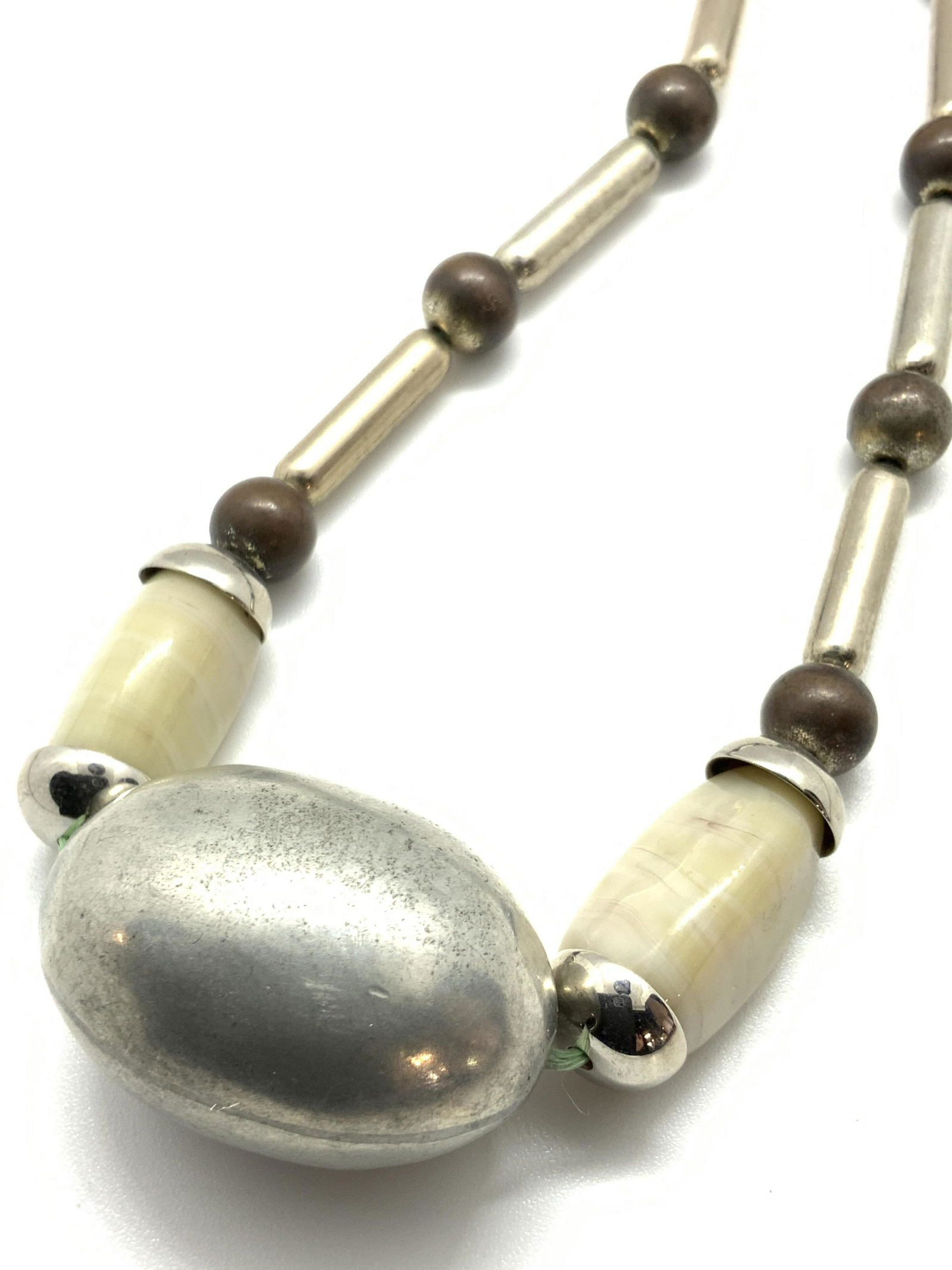 Vintage ALEXIS KIRK Metallic & Glass Bead Necklace: A vintage choker style necklace featuring metallic bead and glass beads. The metalwork beads are circular, oval, and cylindrical in form. Their colors range from silver to brown tones. The glass beads