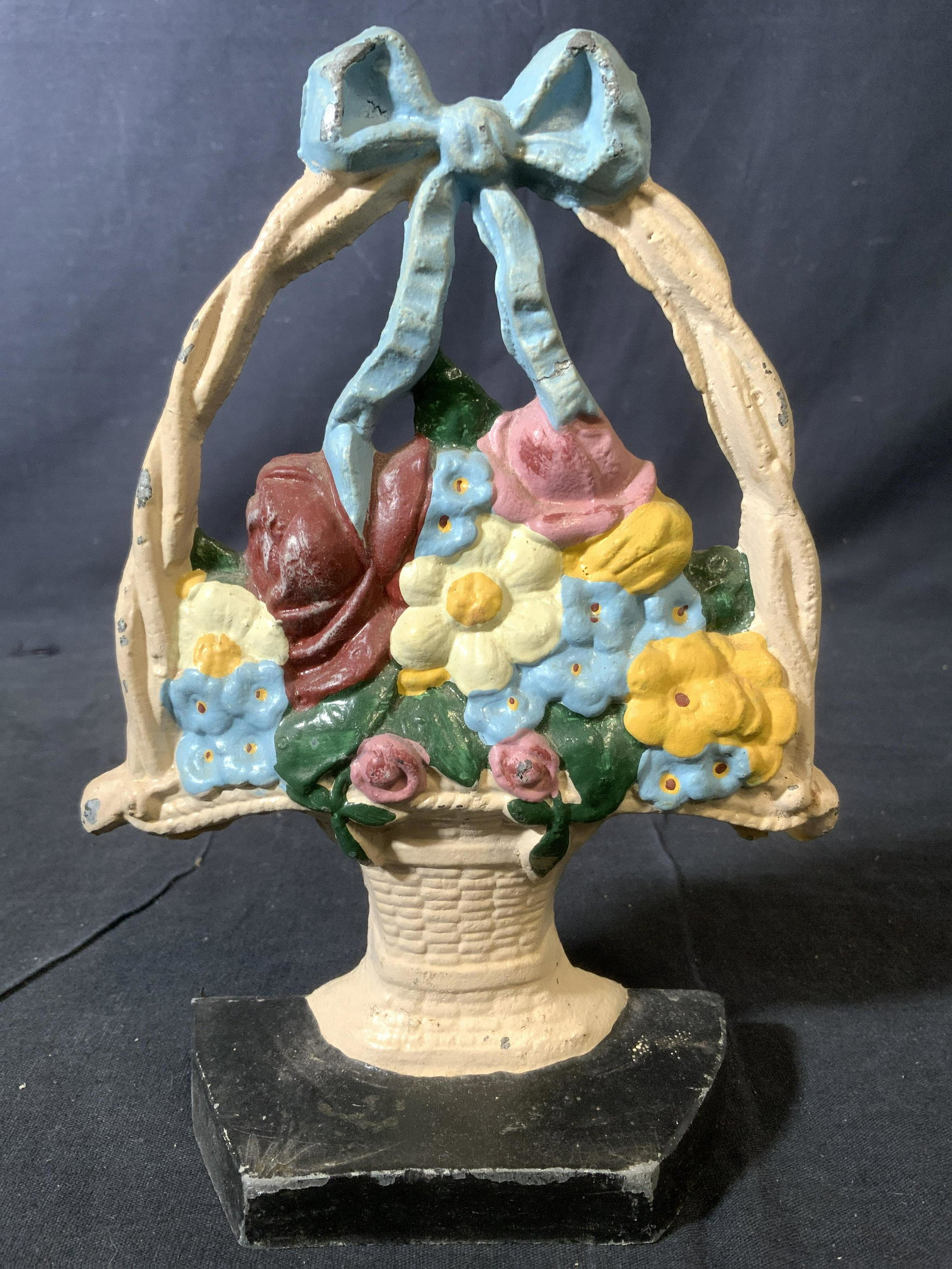 HERITAGE METALCRAFT Vintage Cast Iron Doorstop: Backside of piece has tag which reads Doorstop is vintage and iron. Piece has multi toned floral detail within a ribboned basket. Piece measures approx 8 inches tall 6 inches wide 2.5 inches deep. Doo