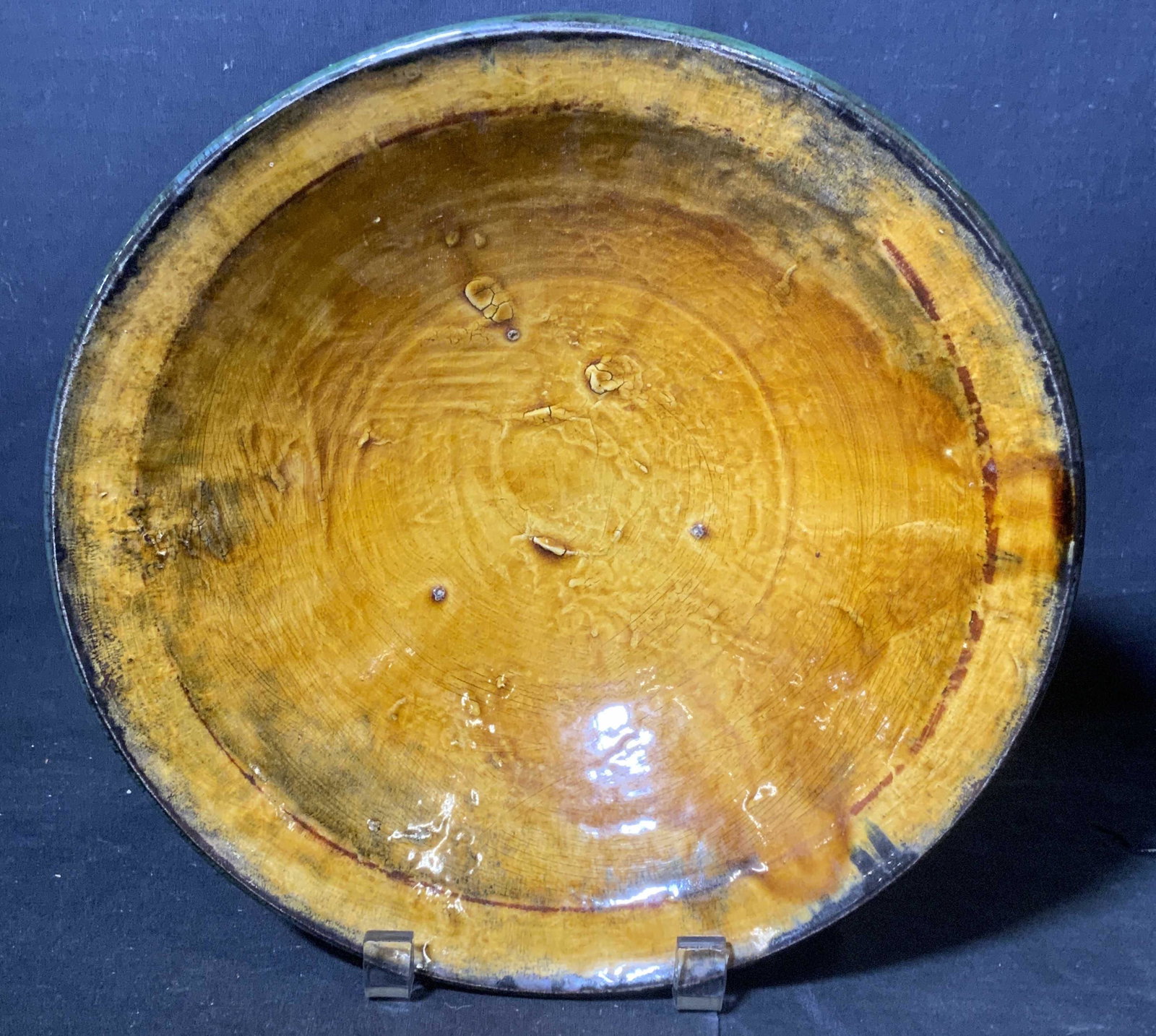 POTLUCK STUDIOS Glazed Earthenware Bowl: Glazed earthen ware bowl, underside is unglazed. Possibly hand spun, possibly vintage. Underside reads as POTLUCK STUDIOS MODERNA NY. Well of bowl is amber in tone. Measures approx 3 inches H, and 10 