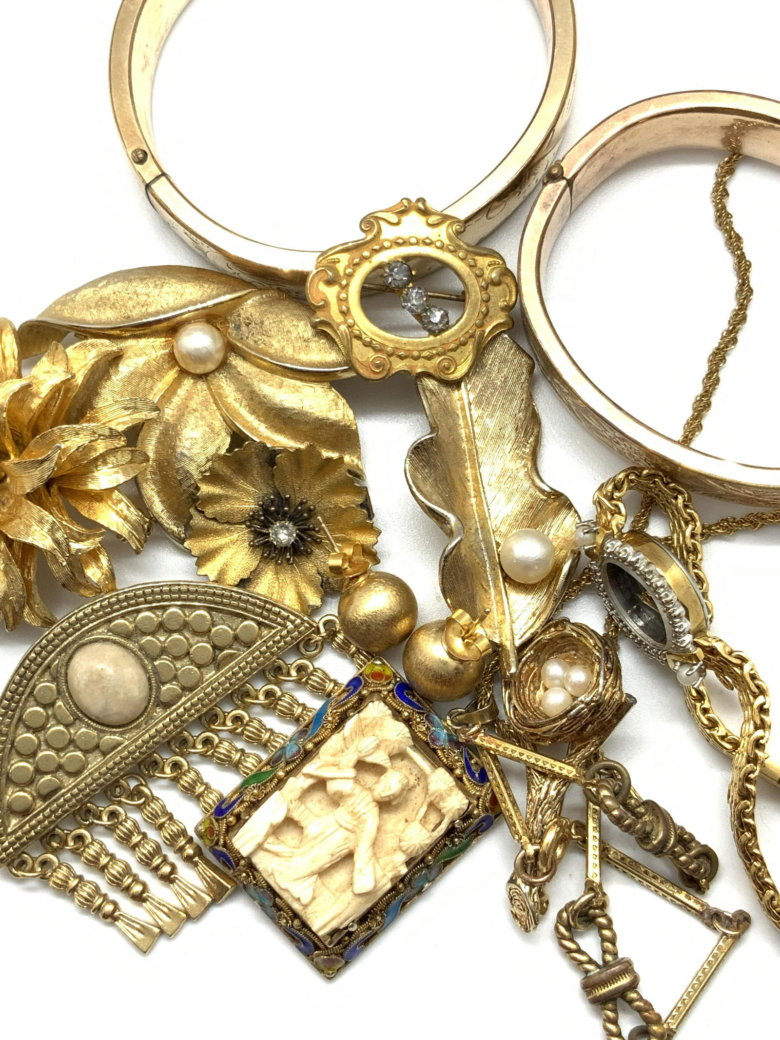 13pc Antq & Vntg HATTIE CARNEGIE & More, Jewelry: Thirteen antique & vintage jewelry items that include a pair of earrings, bracelets (3), brooches (7), a watch, and a necklace. All pieces are crafted from gold tone metal. Some pieces feature pearles