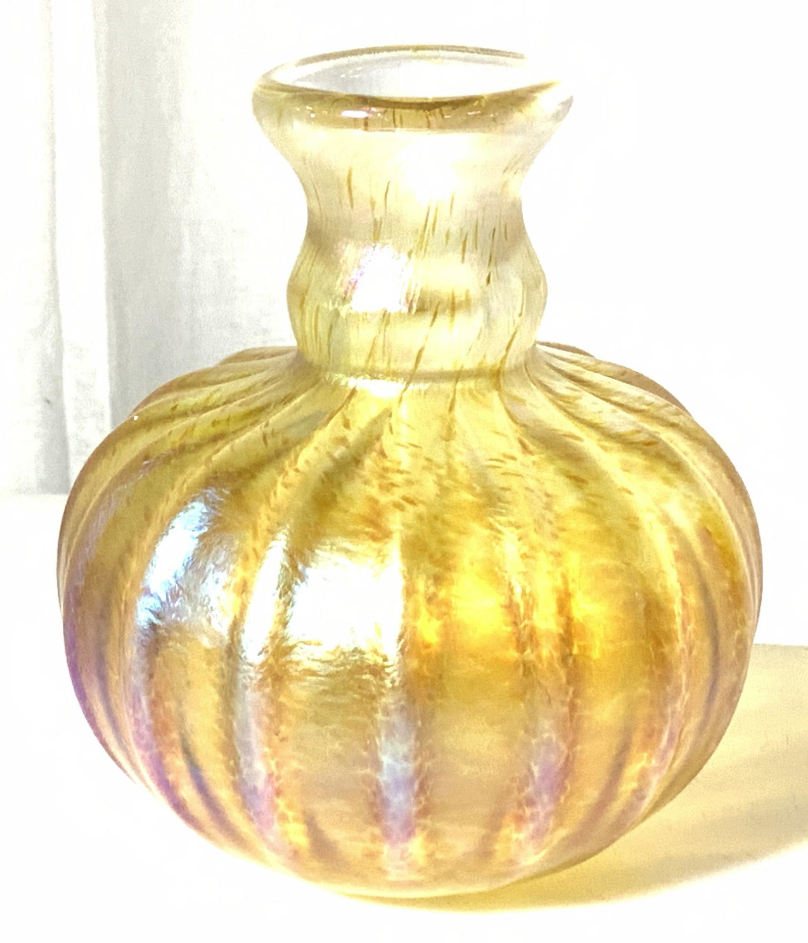 FELLERMAN SIGNED Amber Iridescent Glass Bud Vase: Ribbed pattern Bud vase, coated in an iridescent yellow, gourd shape, 4.5 in. Ht, 4 in. W. SIGNED ‘ FELLERMAN ‘02 ‘ Stephen Fellerman is a renowned glass artist who created one-of-a-kind pieces 