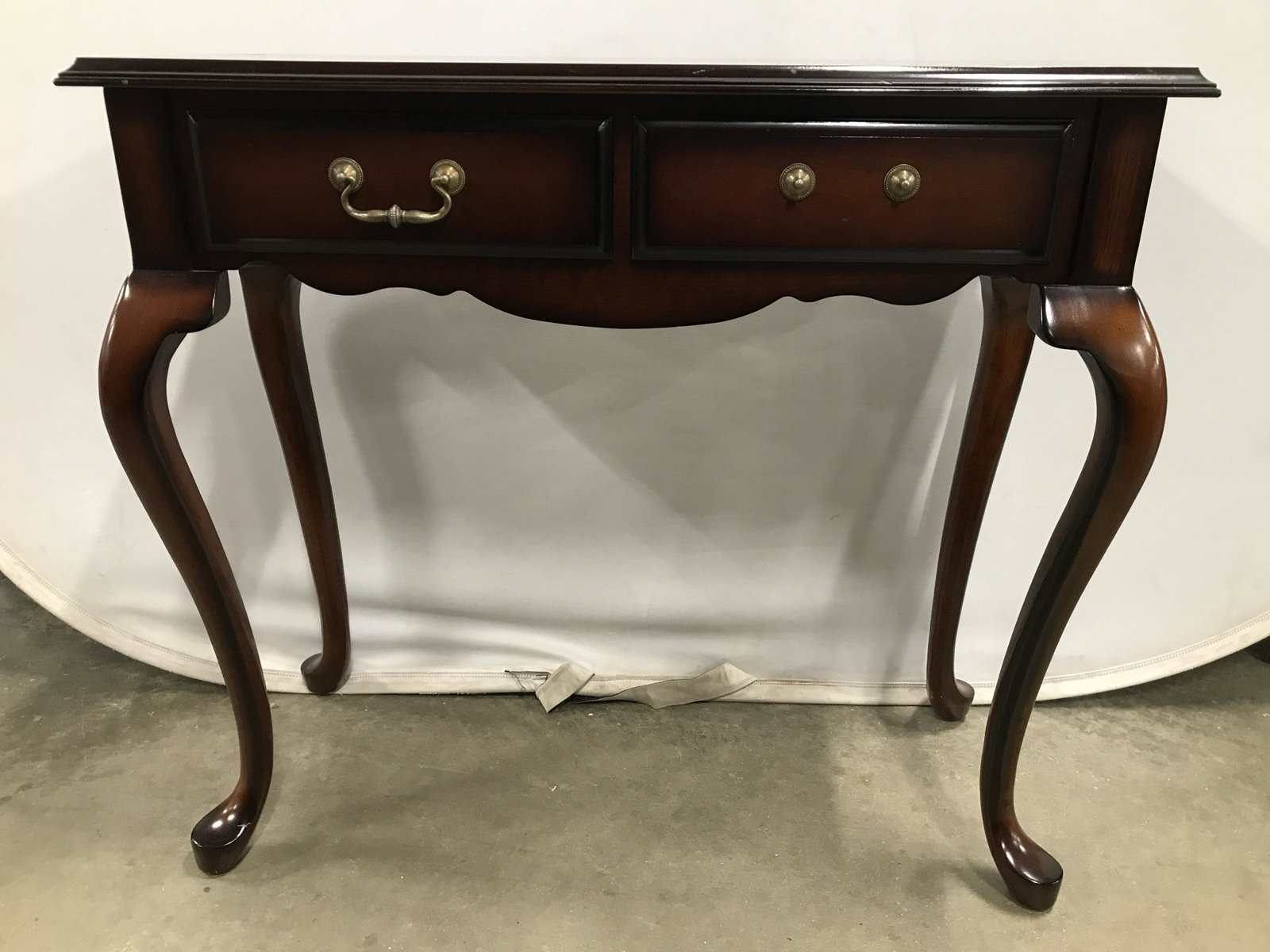 BOMBAY Low Wooden Console Table: Underside of tabletop reads THE BOMBAY COMPANY. Table has 2 drawers & 4 carved wooden Cabriole legs. Piece is possibly mahogany. Measures approximately 32 inches long 30 inches tall 13 inches deep. On