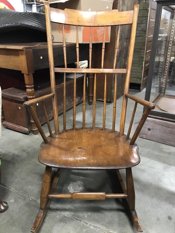 Vintage Wooden Spindle Back Rocking Chair: Rocking chair is wooden. Piece has spindle style backrest. Chair possibly has some hand made elements. Piece measures approximately 39 inches tall 20 inches wide 25 inches deep. Piece has some wear du