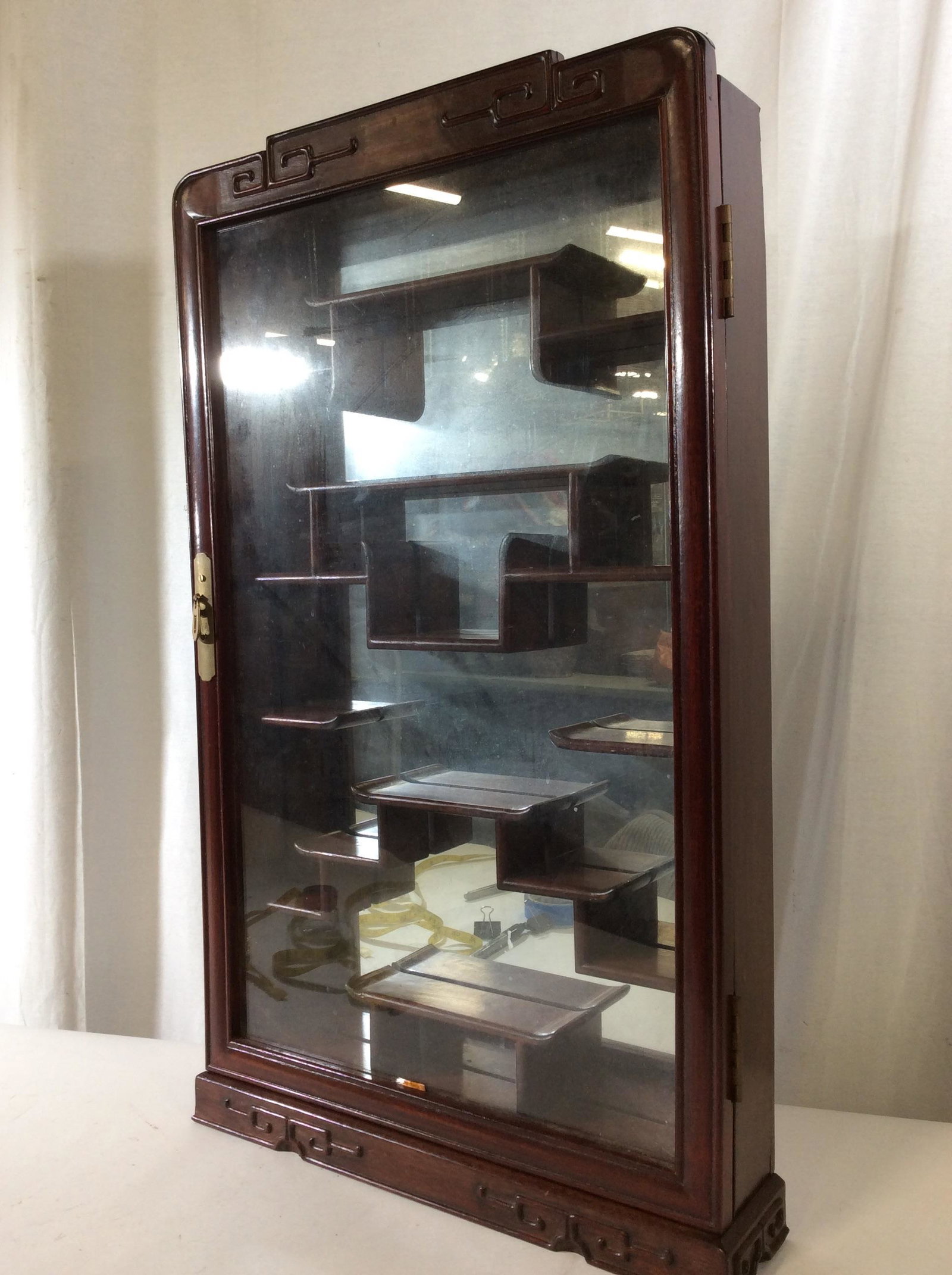 Asian Wood Display What Not Shelf: Large wood cabinet with door that opens, heavy wood, possibly rosewood or with reddish treatment. Tongue and groove construction, backside mirror, Leiwen Design, distinct Asian style shelving. Measure
