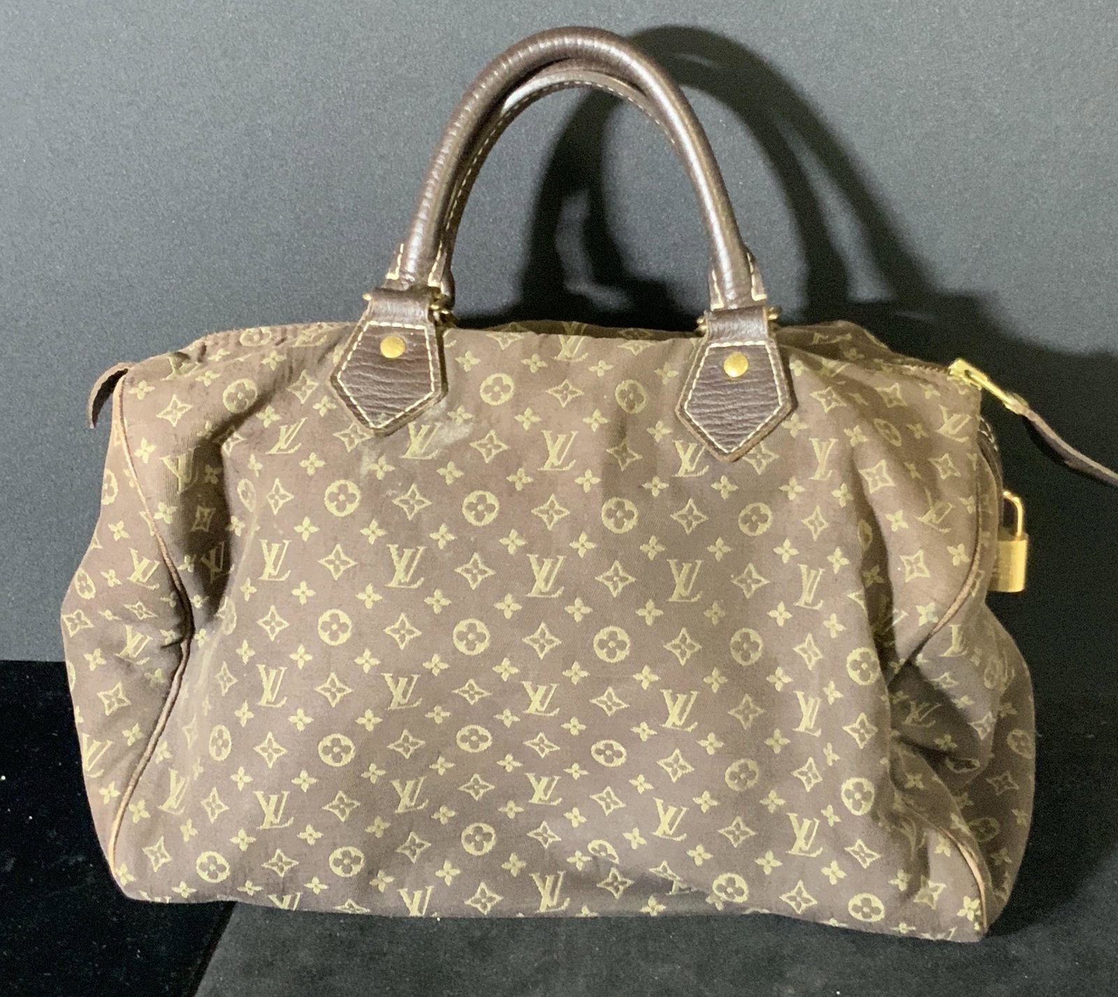 LOUIS VUITTON Monogram Speedy Handbag: Dark brown purse with classic Louis Vuitton monogramming throughout exterior fabric. Cowhide leather trimming. Gold tone hardware, zipper & lock bobble, both etched Louis Vuitton. Some wear to exterio