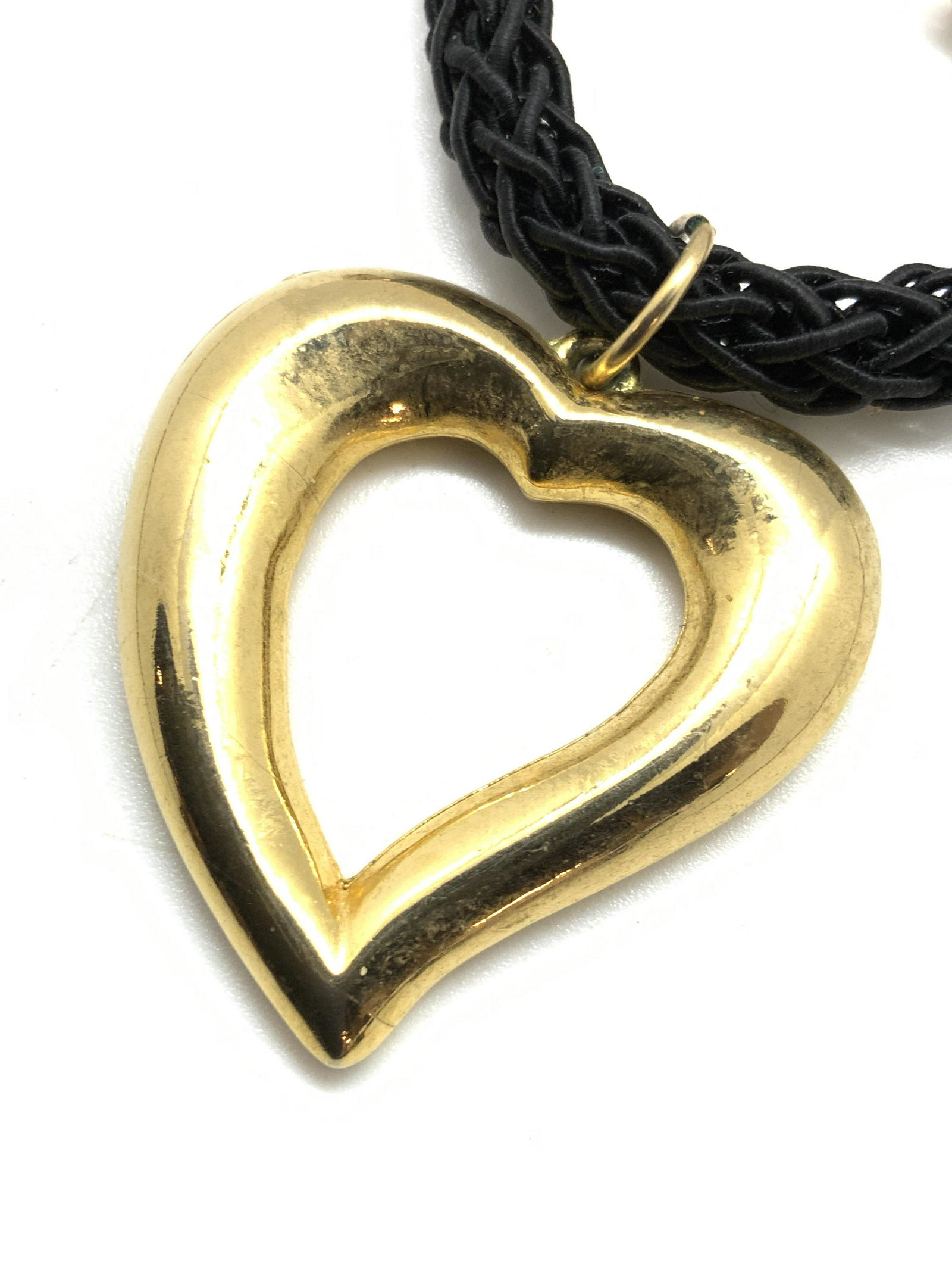 Heart Form Pendant Choker Style Necklace, Jewelry: A black braided cord choker style necklace with a gold tone metal, heart form pendant. The pendant is polished. The necklace secures with an adjustable lobster claw clasp. Approx. Length 14 in. Pendan