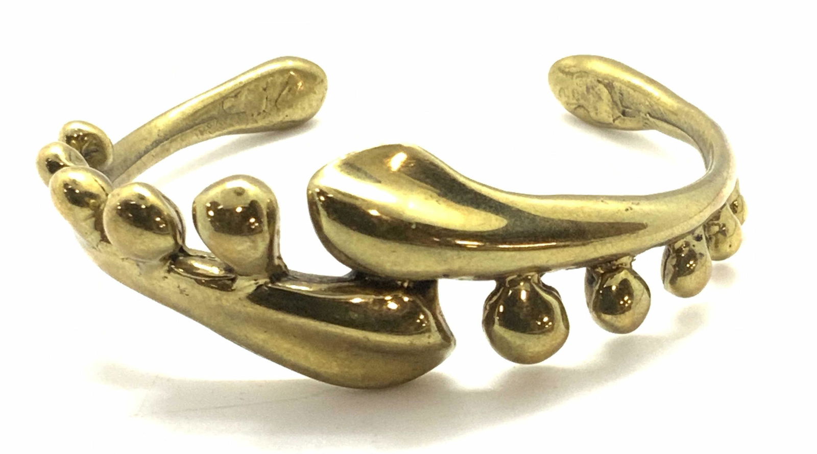 Vintage Polished Gold Tn Cuff Bracelet, Jewelry: Vintage, possibly antique, polished antiqued gold tone metal cuff bracelet. The piece features spherical forms lining the edges of the center band. Approx. 2 in. Diameter. Approx. Distance between cuf