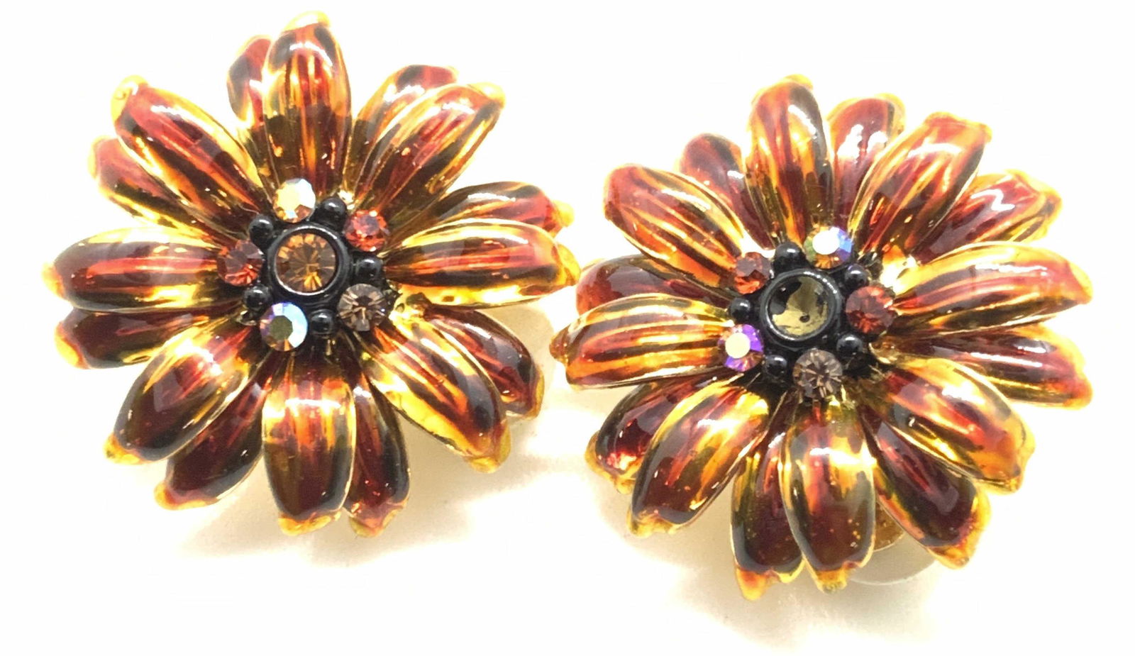 JOAN RIVERS Sign Metallic Floral Earrings, Jewelry: Possibly vintage metallic floral earrings. The petals are layered, giving the earrings a 3D effect. At the center of each flower there is a cluster of colorful, faceted rhinestones. One rhinestone mis